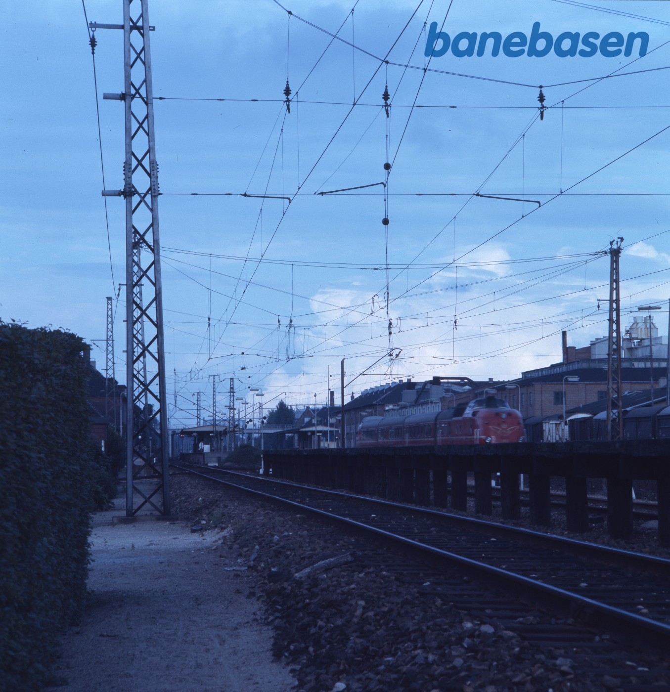 MA lyntog i rød bemaling - S-bane ledninger i forgrunden MA lyntog i rød bemaling - S-bane ledninger i forgrunden