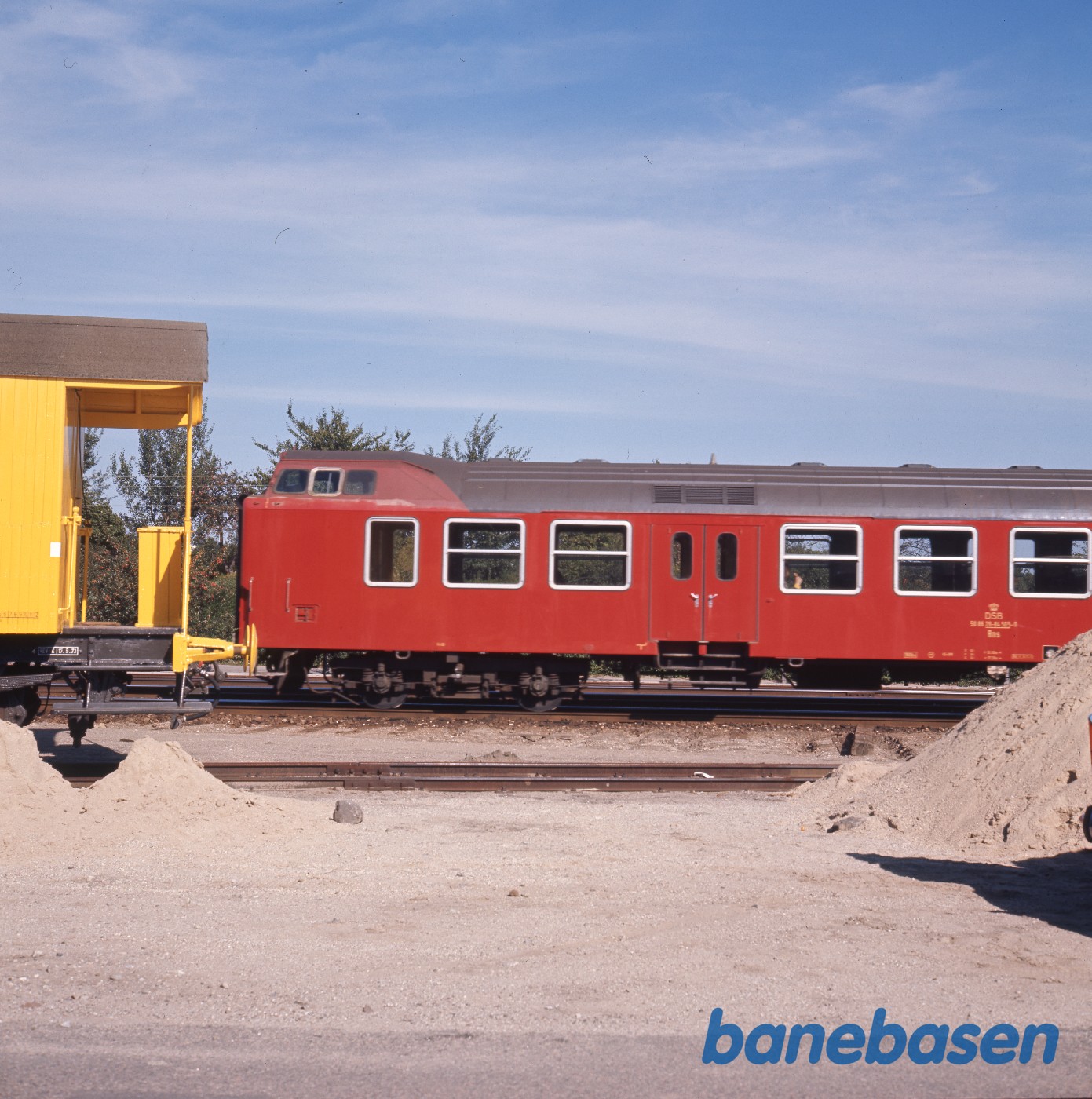 Gul arbejdsvogn i forgrunden, Bns i baggrunden Gul arbejdsvogn i forgrunden, Bns i baggrunden