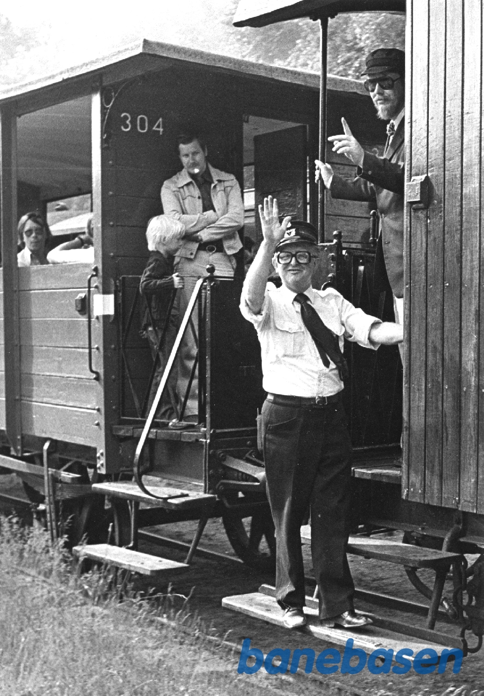 Togføreren vinker til fotografen, et sommertog Togføreren vinker til fotografen, et sommertog