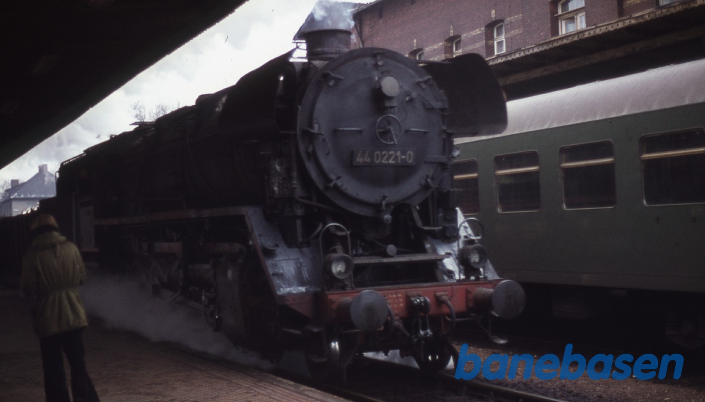 Damplokomotiv på station. Godstoget kører forbi perronen Damplokomotiv på station. Godstoget kører forbi perronen