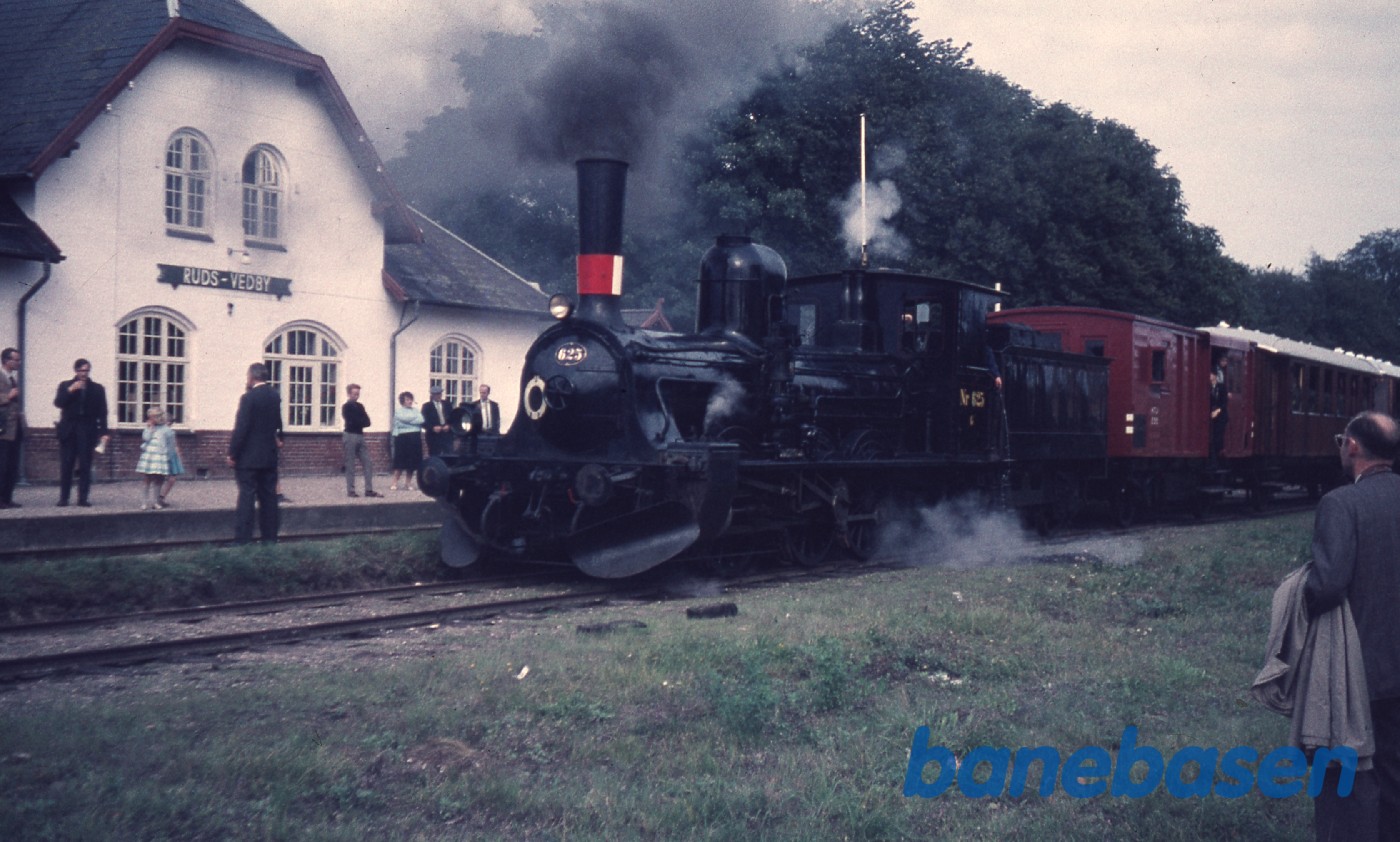Udflugtstoget holder på stationen mens jernbaneentusiasterne ser på Udflugtstoget holder på stationen mens jernbaneentusiasterne ser på