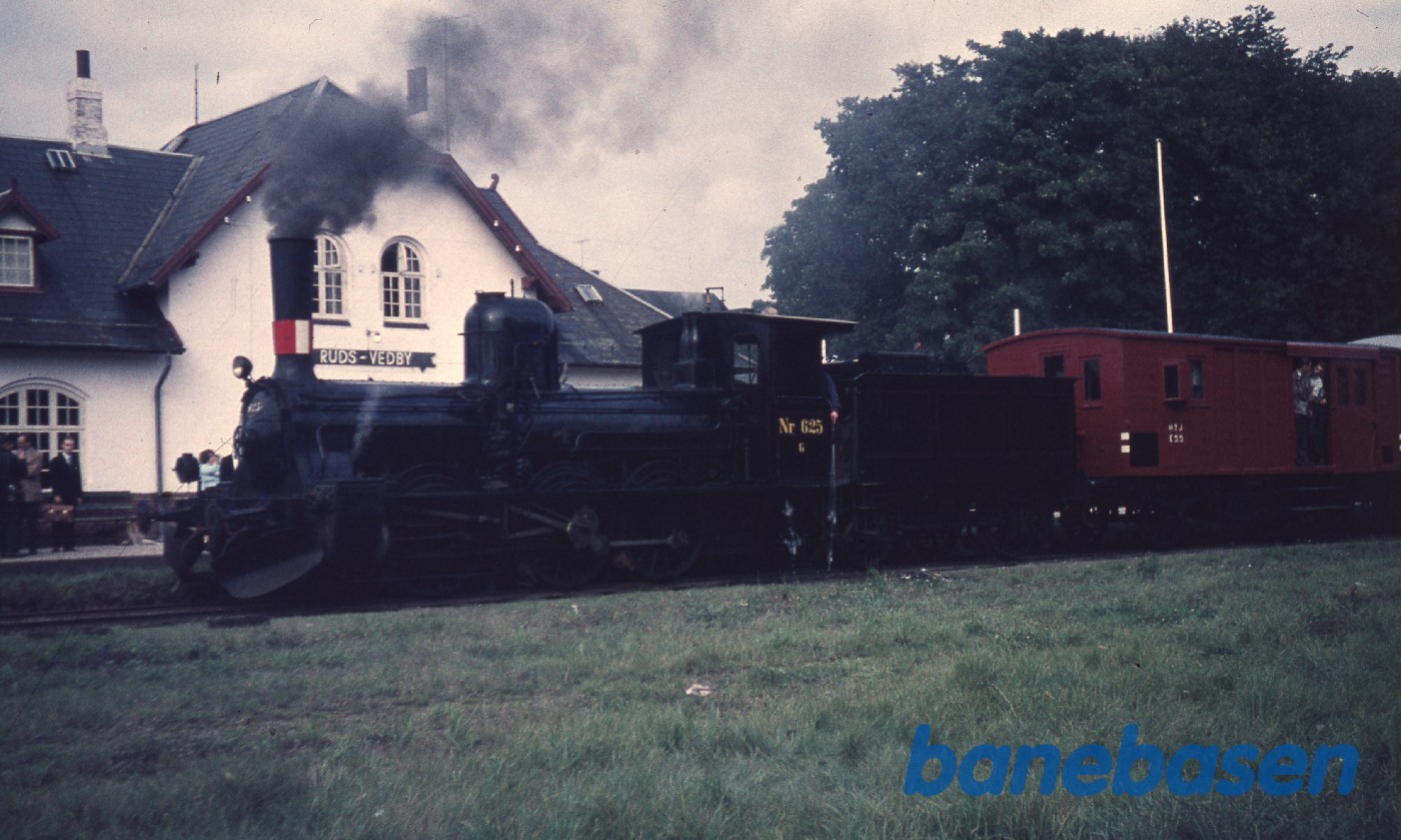 Udflugtstoget holder på stationen mens jernbaneentusiasterne ser på Udflugtstoget holder på stationen mens jernbaneentusiasterne ser på