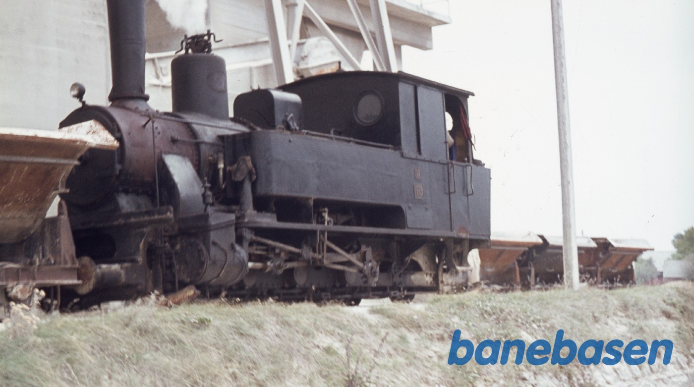 Damplokomotiv trækker af sted med læssede kalkvogne nede i kalkbrudet Damplokomotiv trækker af sted med læssede kalkvogne nede i kalkbrudet