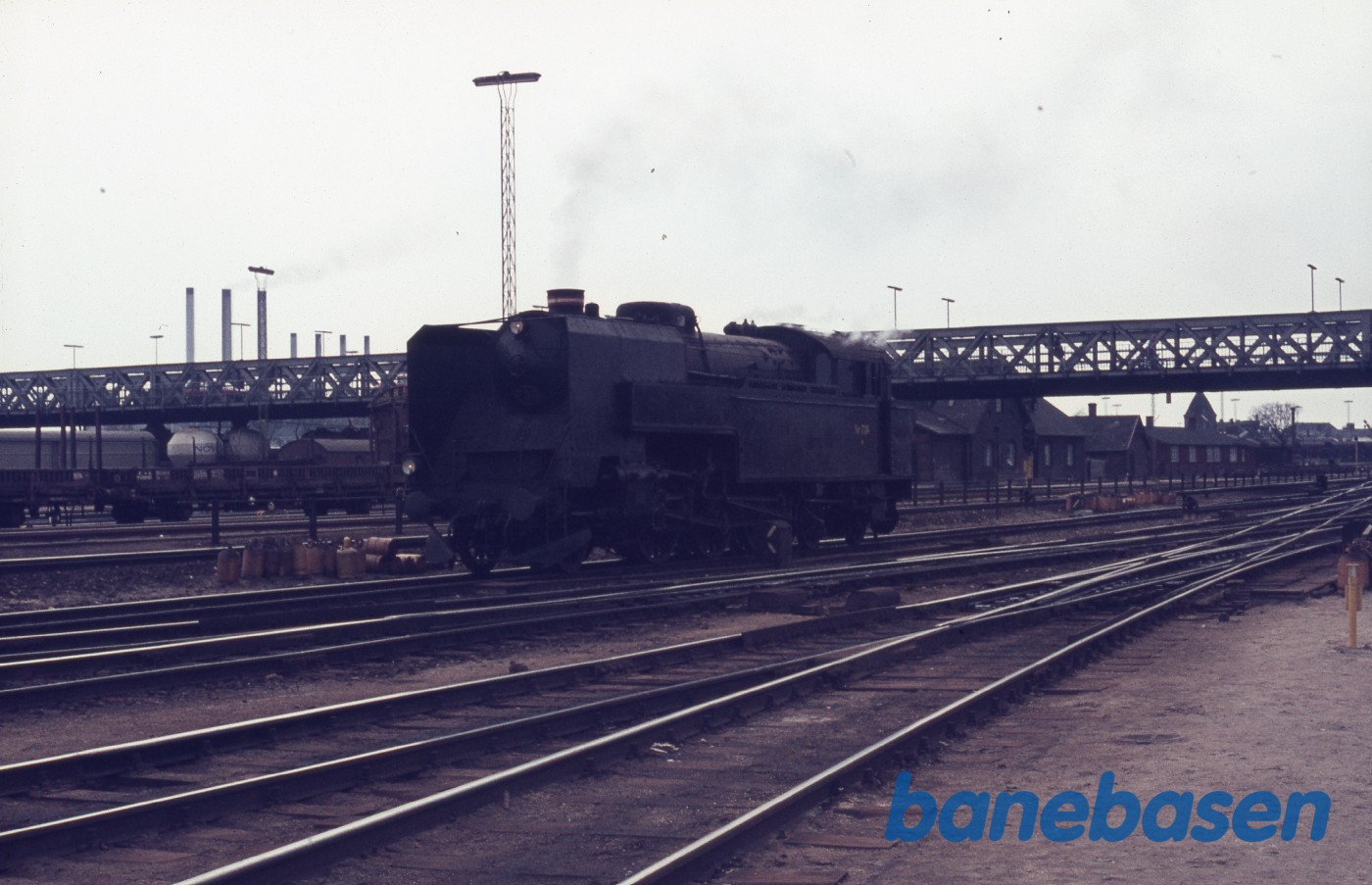 Mørkt damplokomotiv holder ude ved Dybbølsbro. Den gamle bro i baggrunden Mørkt damplokomotiv holder ude ved Dybbølsbro. Den gamle bro i baggrunden