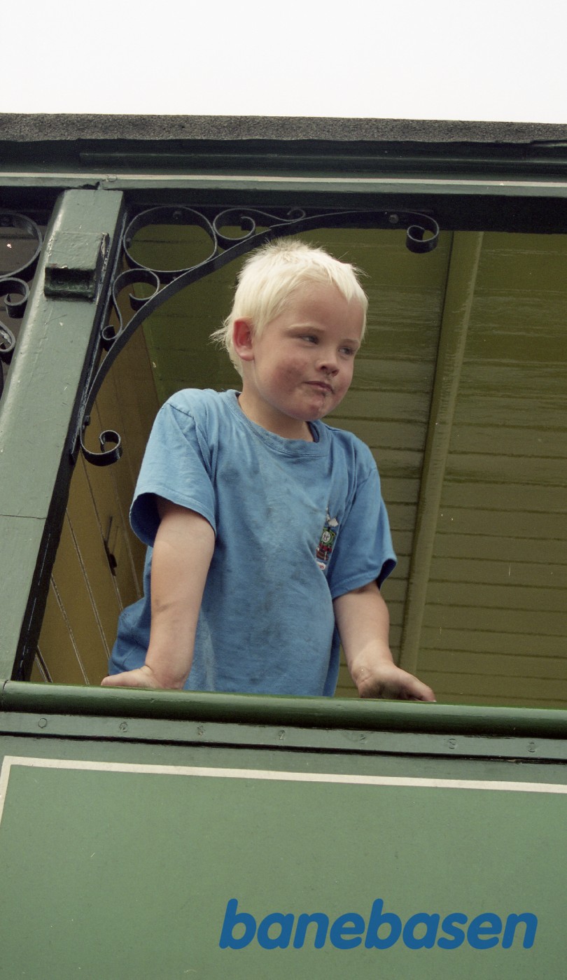 En glad dreng kigger ud af skovvognen En glad dreng kigger ud af skovvognen