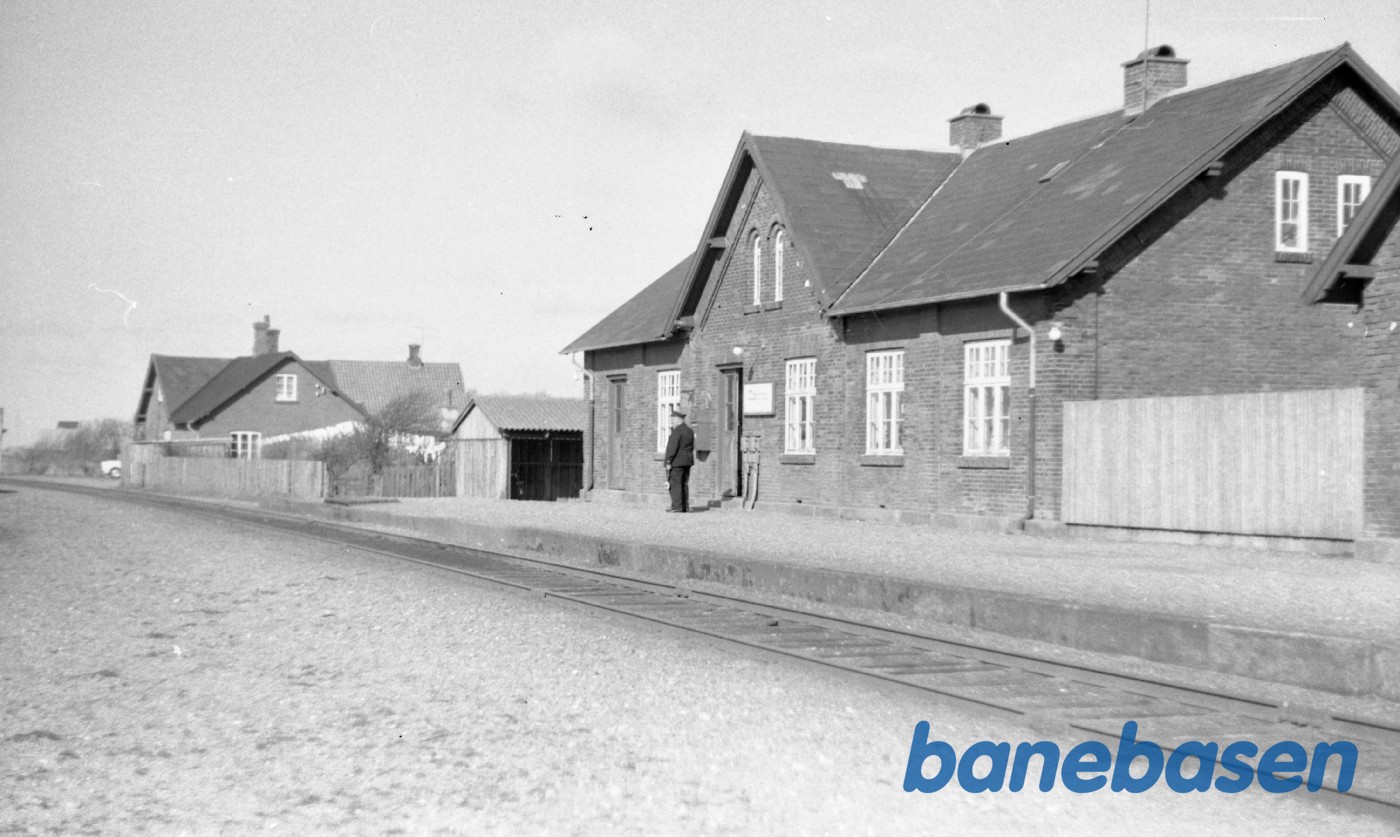 Stationsforstanderen står på peronnen og kigger efter toget Stationsforstanderen står på peronnen og kigger efter toget