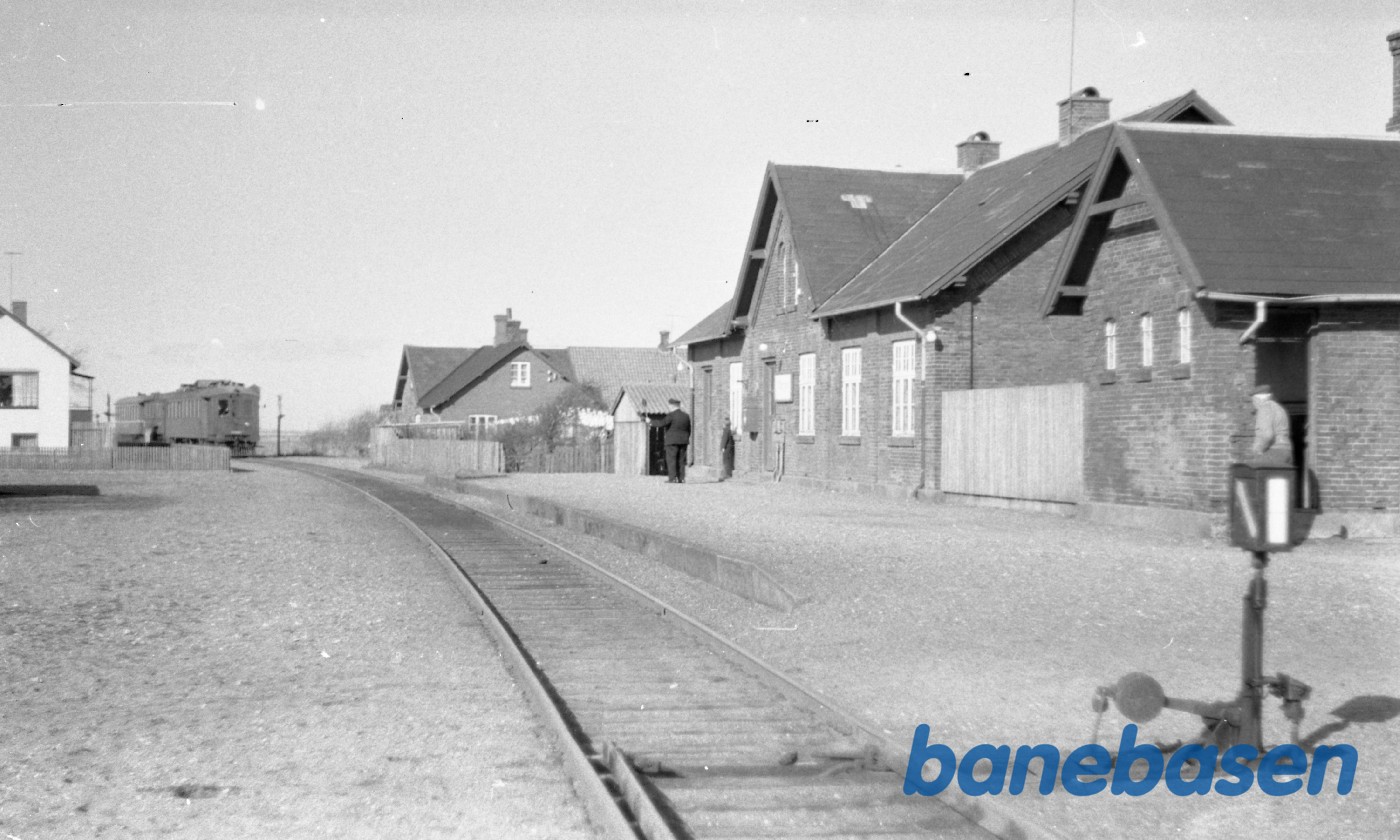 Stationsforstanderen står på peronnen og kigger efter toget Stationsforstanderen står på peronnen og kigger efter toget