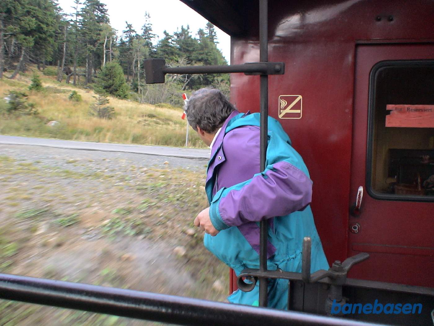 En turist nyder turen fra den åbne endeperron