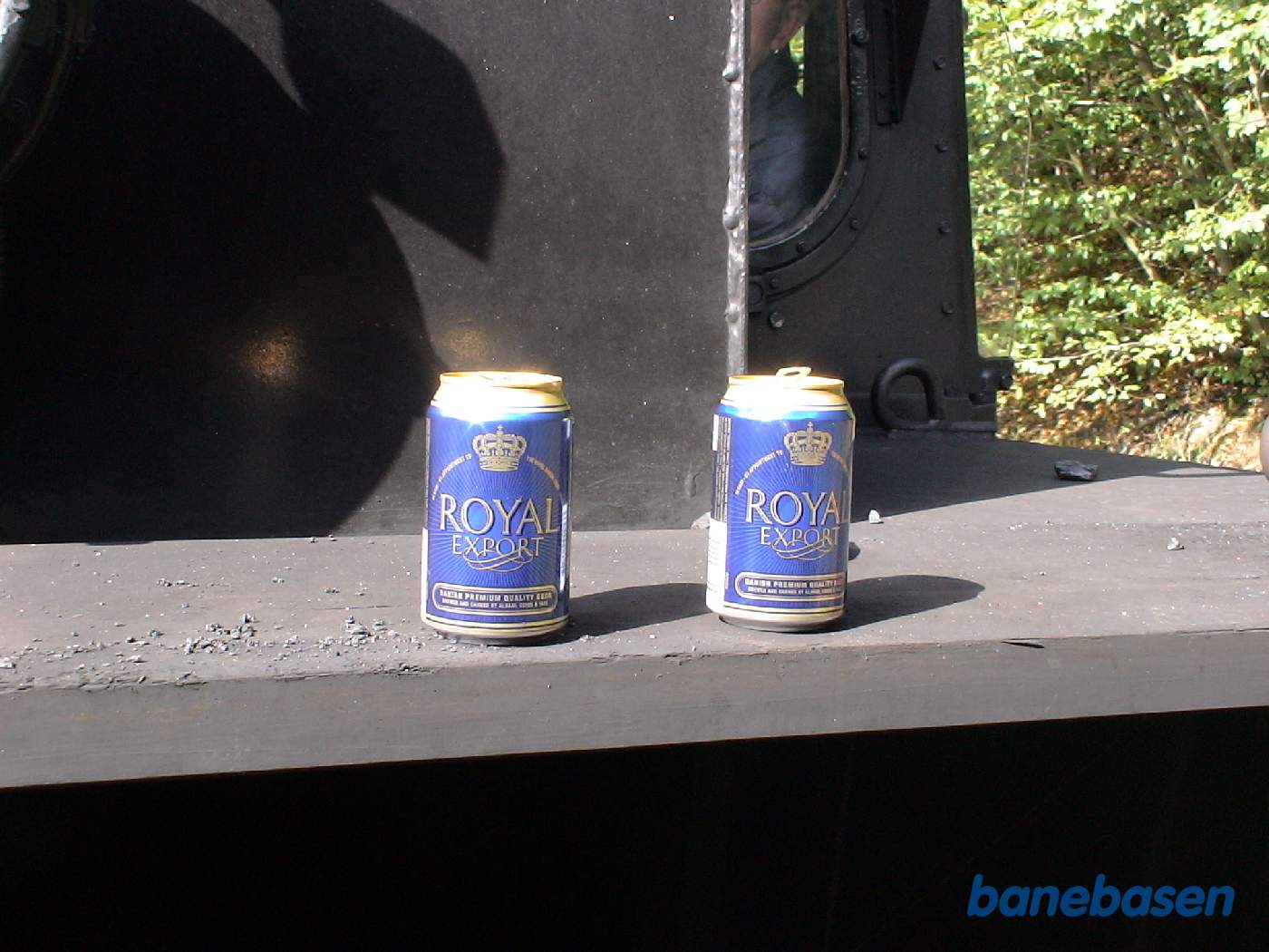 To øldåser stillet op på damplokomotivets fodplade