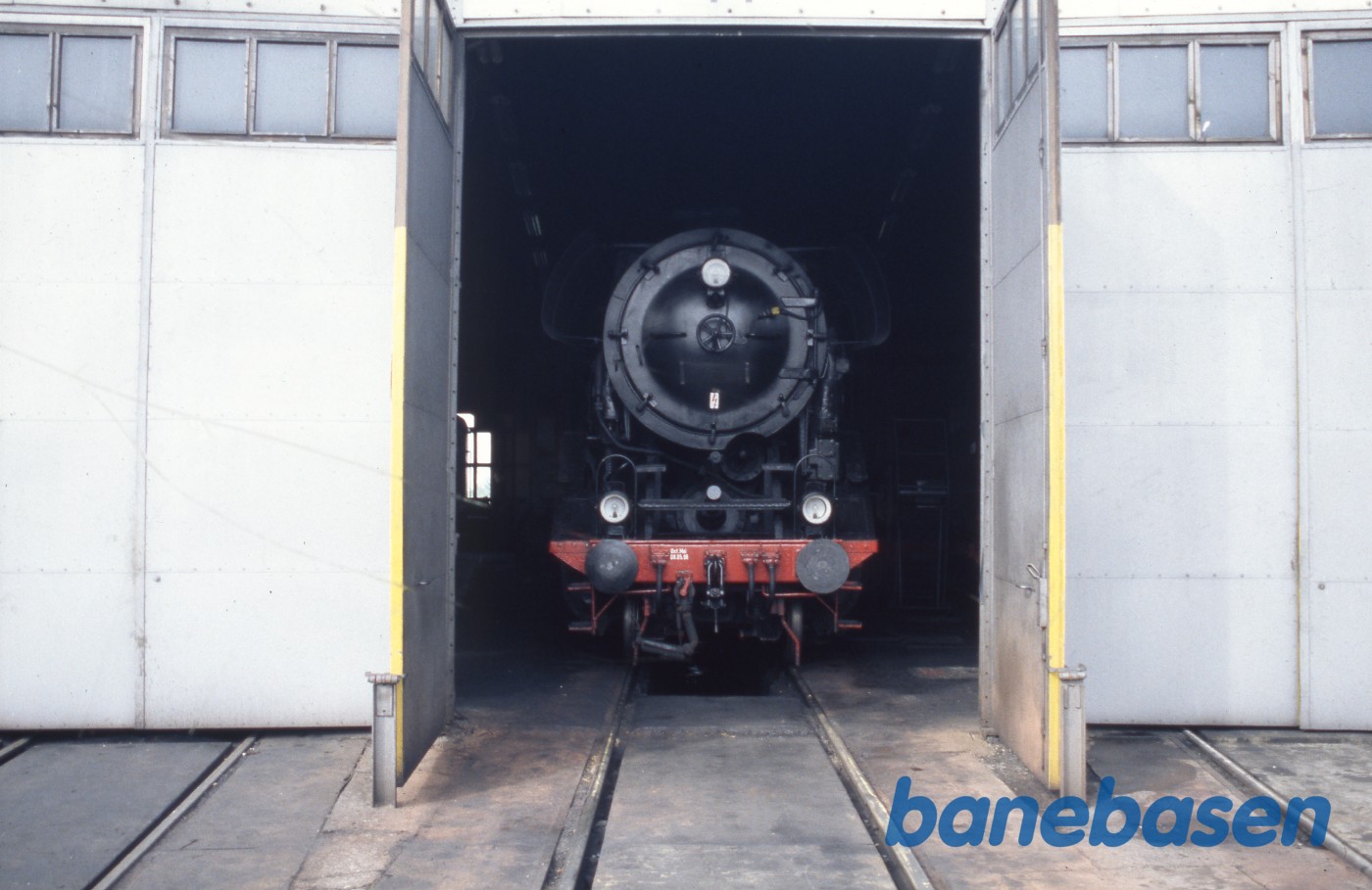 Et damplokomotiv i portåbningen til en remise et ukendt sted Et damplokomotiv i portåbningen til en remise et ukendt sted