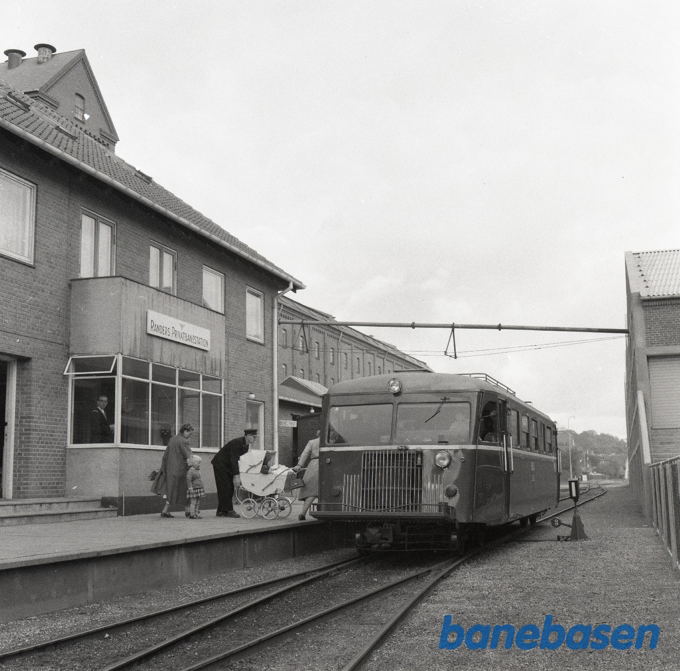 Skinnebustog holder på Randers Privatbanestation. Barnevogn læsses ind. Skinnebustog holder på Randers Privatbanestation. Barnevogn læsses ind.