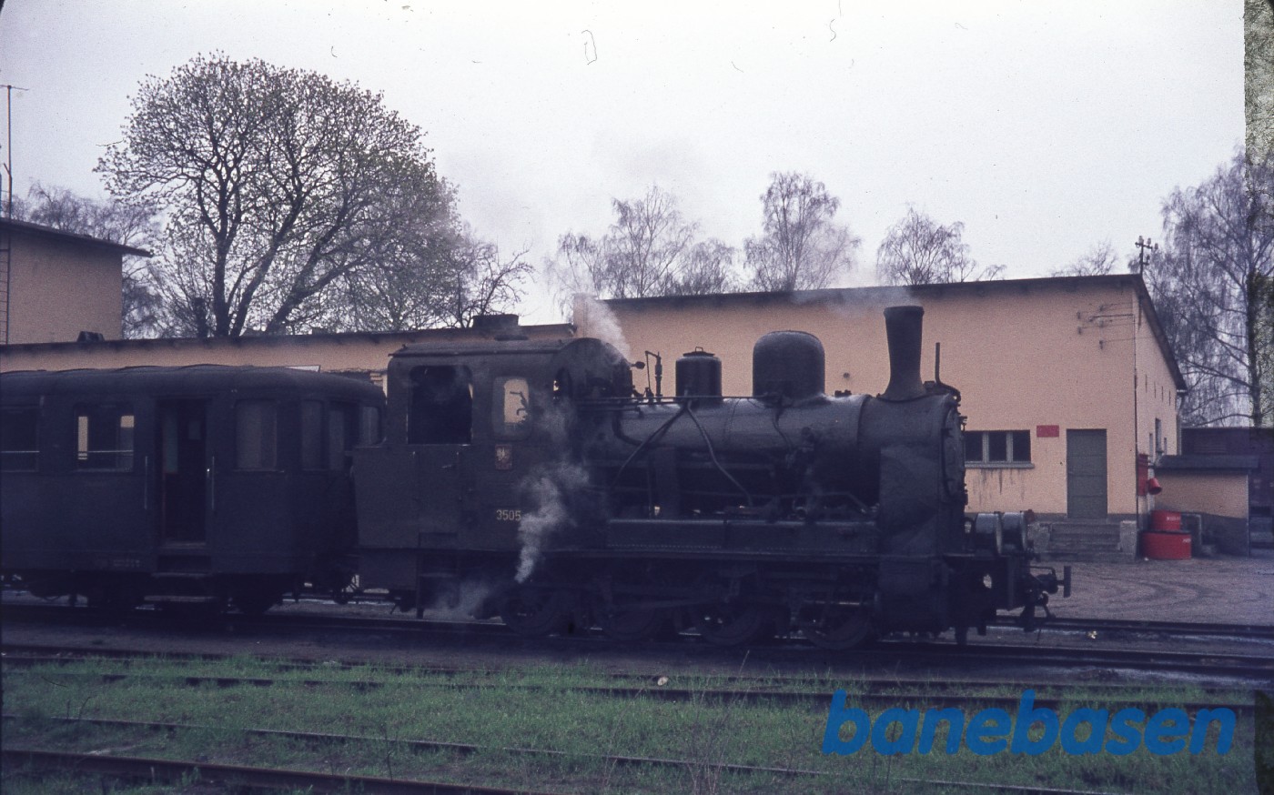 Damplokomotiv med personvogn på stationen