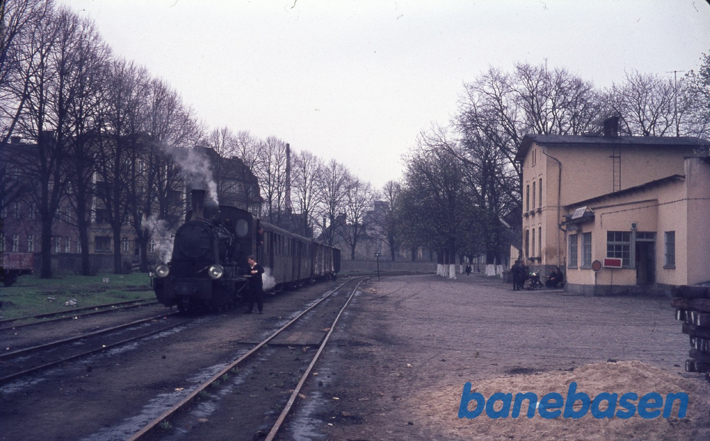Damplokomotiv med personvogne på stationen