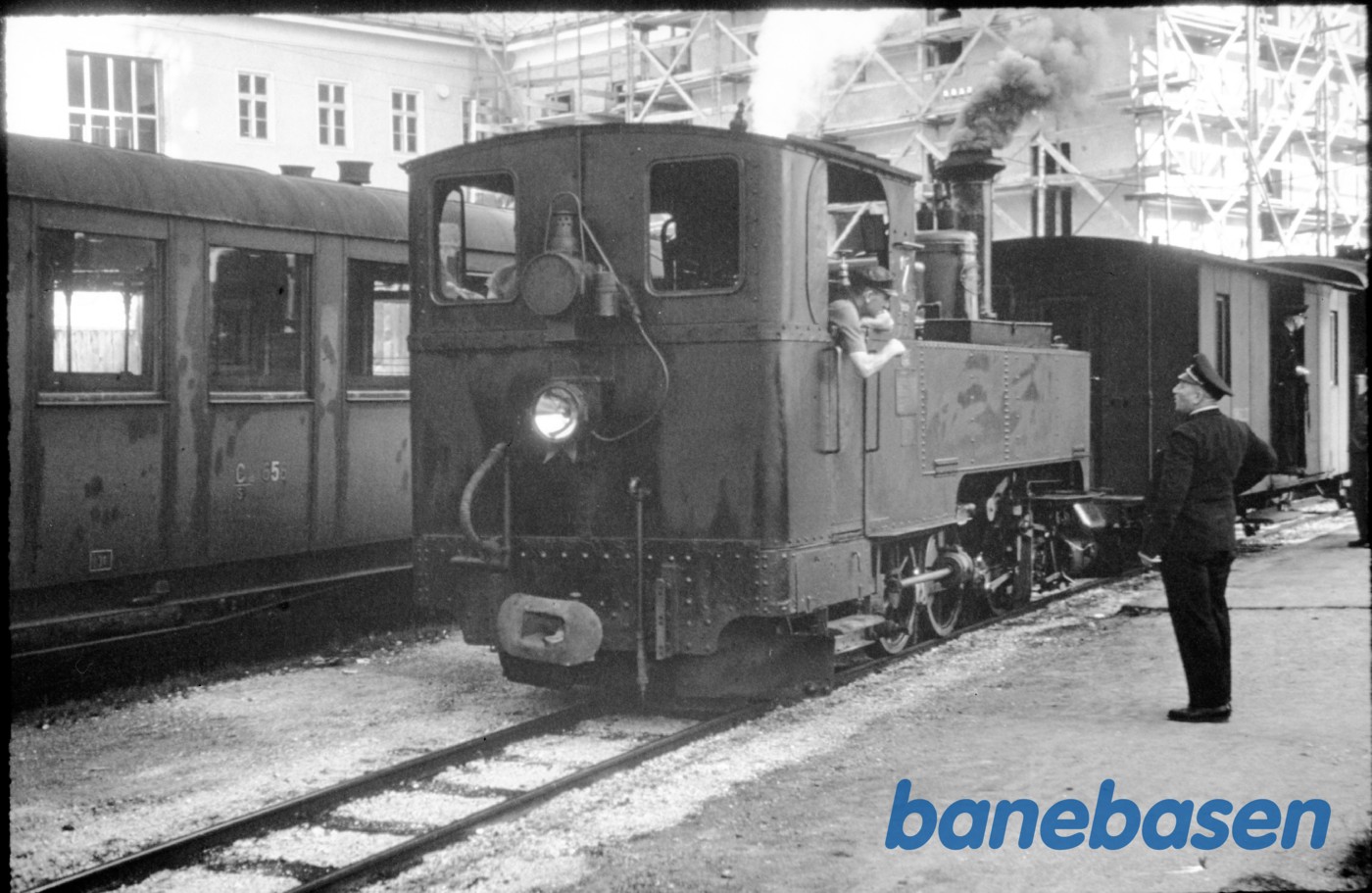 Damplokomotiv med person og pakvogne holder ved en perron Damplokomotiv med person og pakvogne holder ved en perron