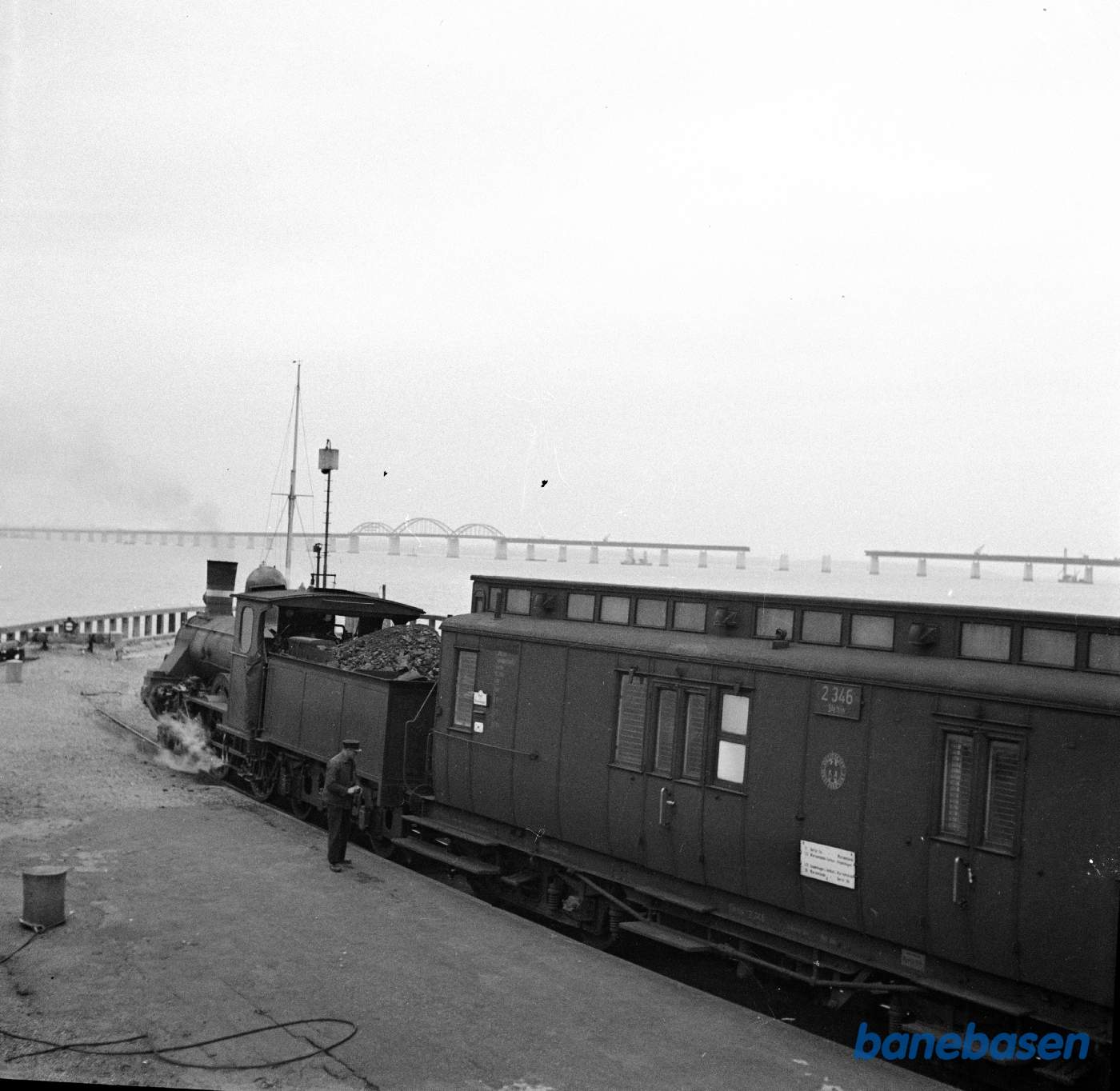 Damplokomotiv Ltr K holder på Orehoved færgestation. Den nye Storstrømsbro under opførelse Damplokomotiv Ltr K holder på Orehoved færgestation. Den nye Storstrømsbro under opførelse