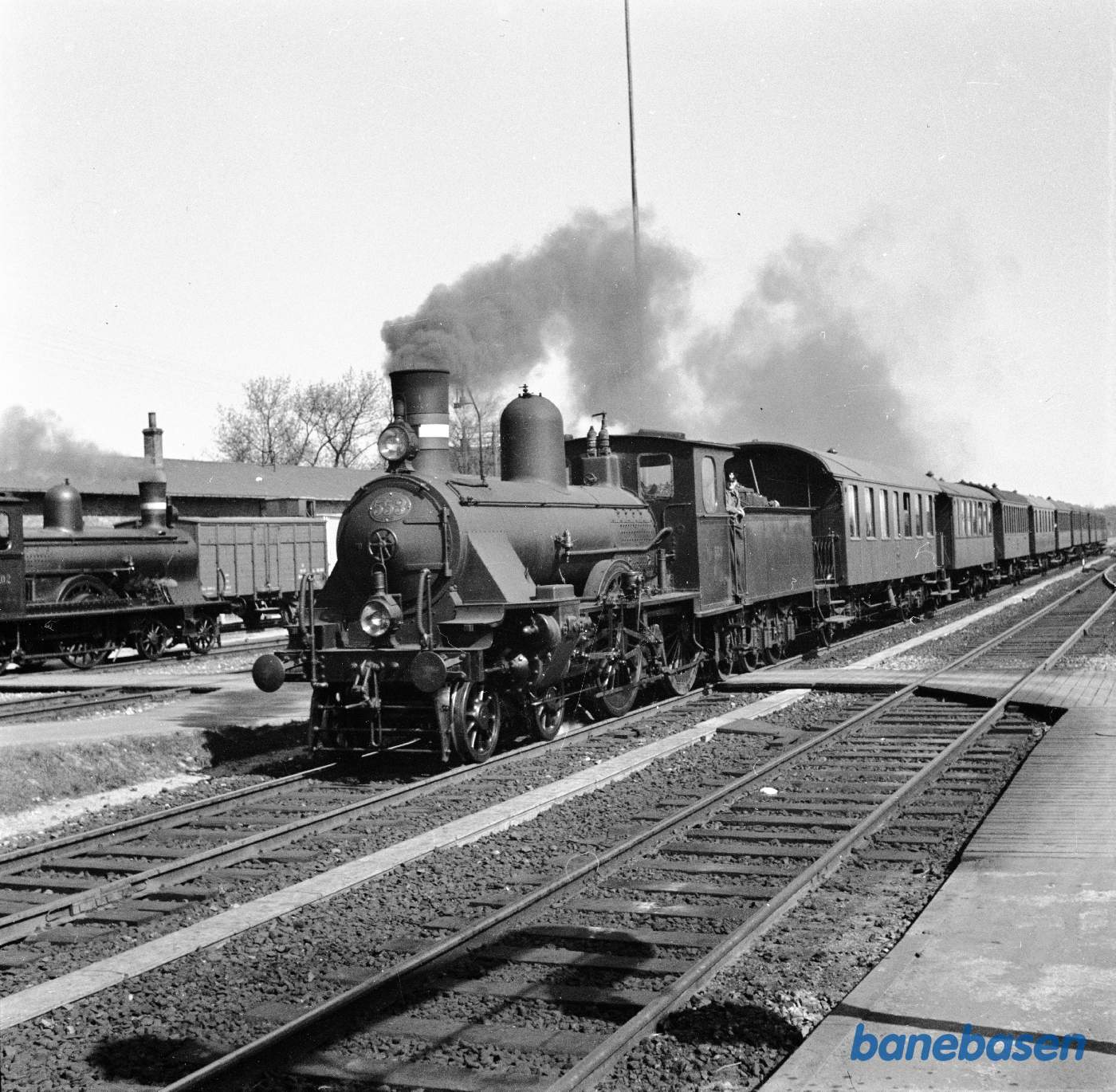 Damplokomotiv K 553 med persontog med toakslede vogne under indkørsel til Roskilde Damplokomotiv K 553 med persontog med toakslede vogne under indkørsel til Roskilde