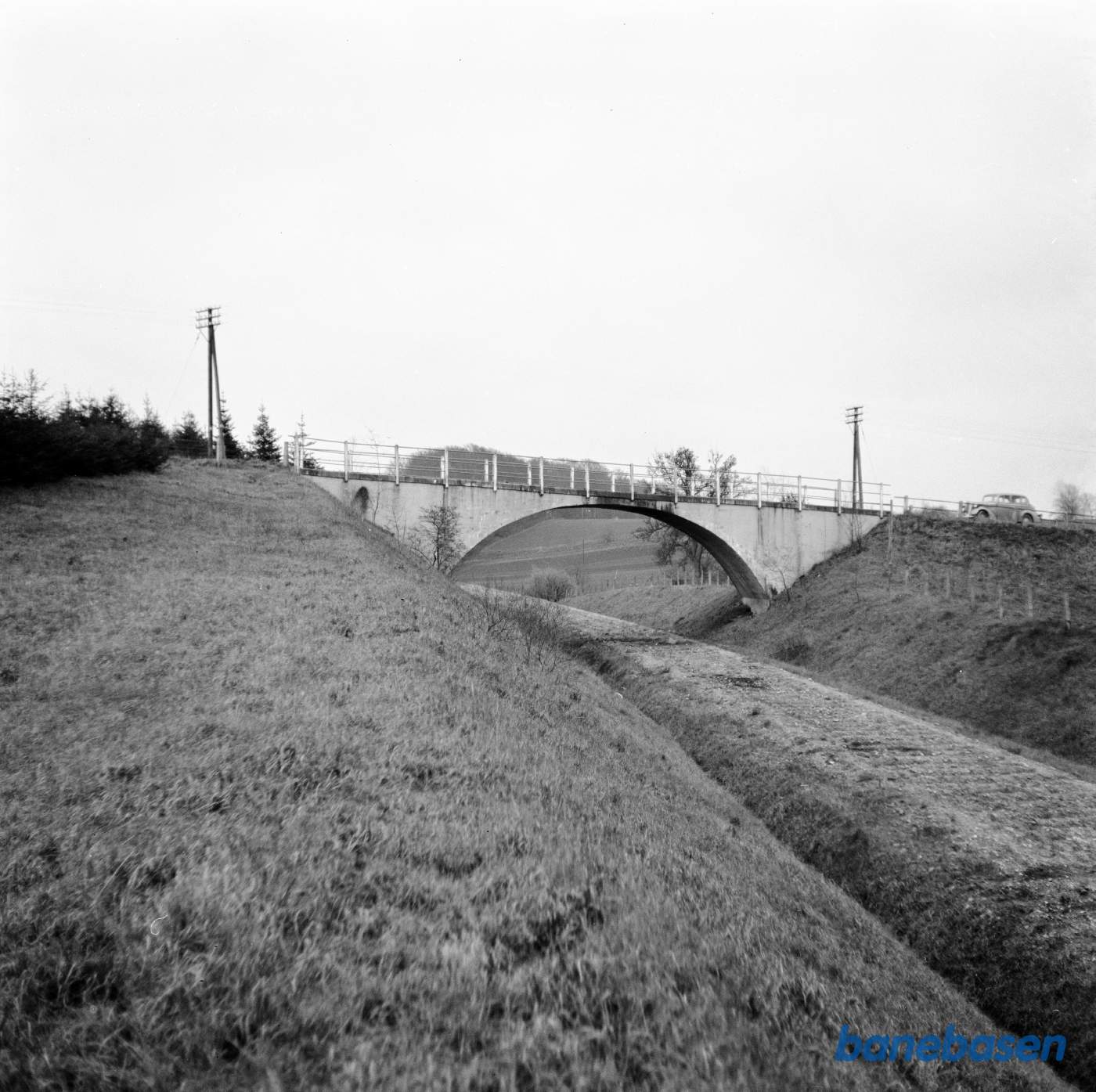 Banetrace uden skinner går under vejbro med bil på. Let venstrekurve. Banetrace uden skinner går under vejbro med bil på. Let venstrekurve.