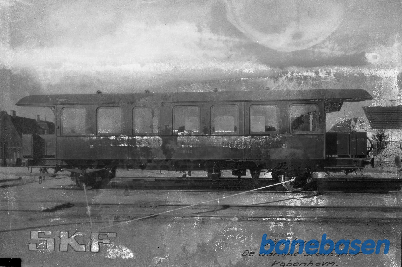 Reklame for SKF. DSB CF 10142 forsynet med SKF rullelejer. Den gule by ses i baggrunden Reklame for SKF. DSB CF 10142 forsynet med SKF rullelejer. Den gule by ses i baggrunden