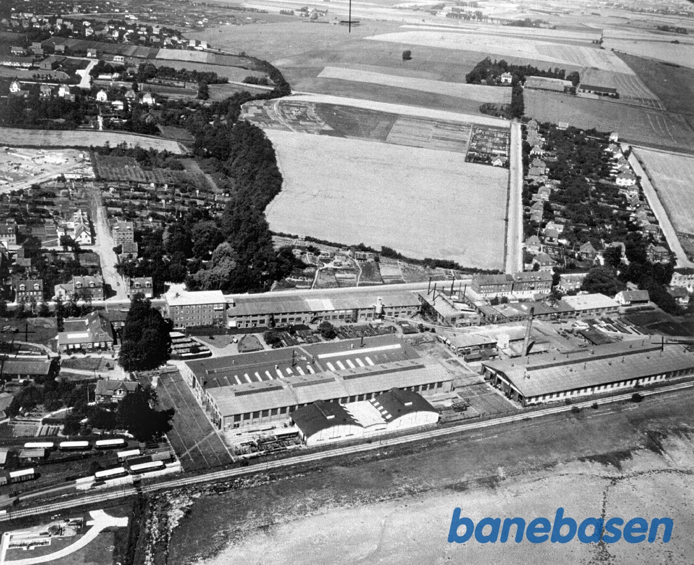 Luftfoto af Vognfabrikken Scandia. Der holder skinnebusser på området Luftfoto af Vognfabrikken Scandia. Der holder skinnebusser på området