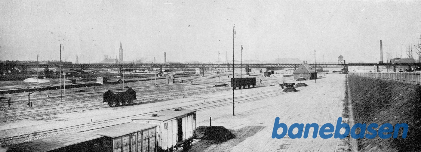 Udsigt fra vest over godsbanegårdens terræn. I baggrunden broen for kulbanen til Vester Gasværk. Udsigt fra vest over godsbanegårdens terræn. I baggrunden broen for kulbanen til Vester Gasværk.