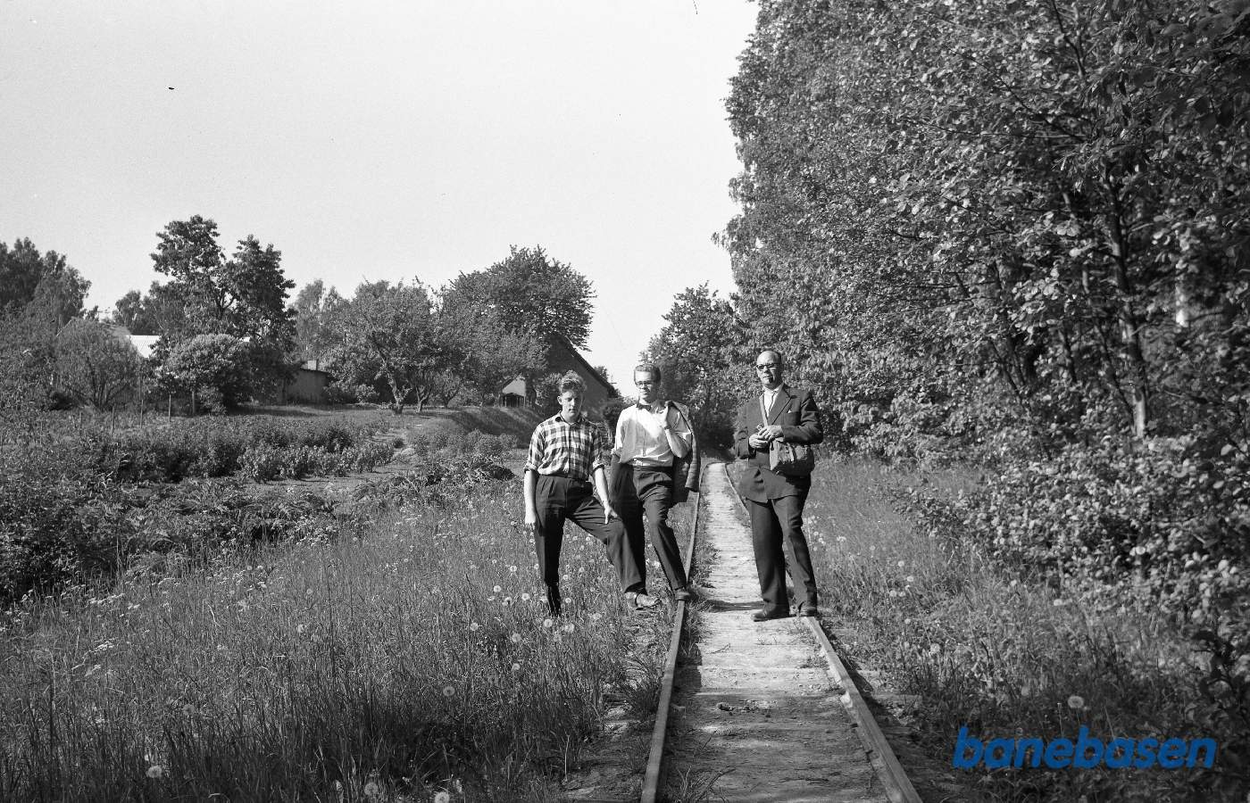 3 personer poserer ved smalspor