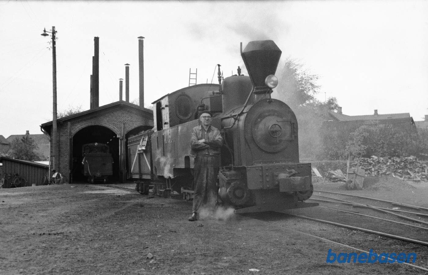 Lokomotivfører poserer foran damplokomotiv Lokomotivfører poserer foran damplokomotiv
