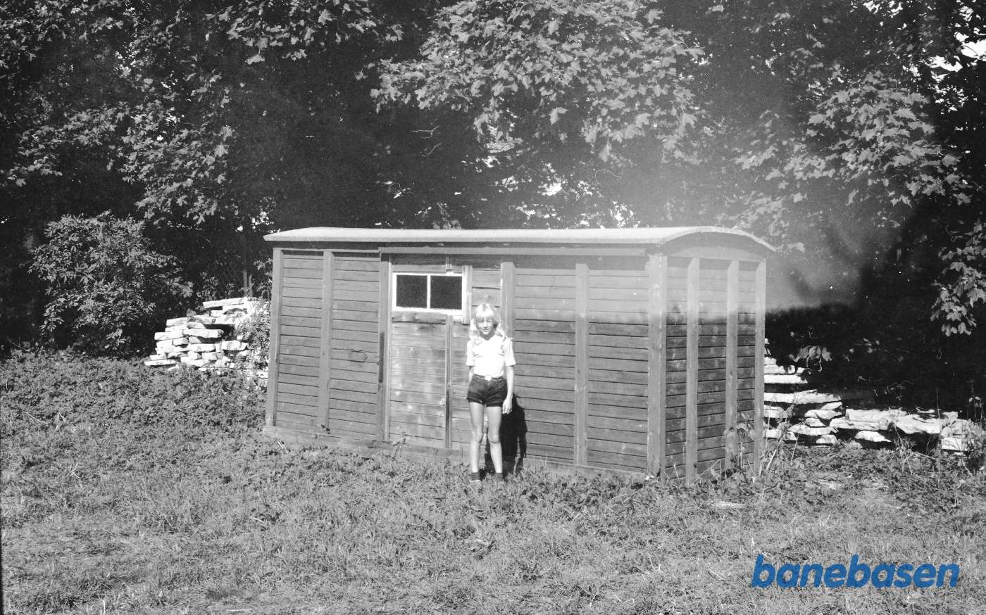 Pige foran vognkasse fra lukket godsvogn, smalspor