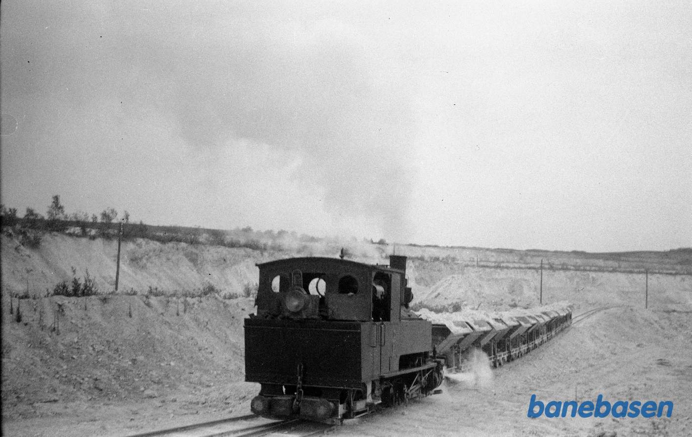 Damplokomotiv på vej op ad bruddet med læssede vogne Damplokomotiv på vej op ad bruddet med læssede vogne