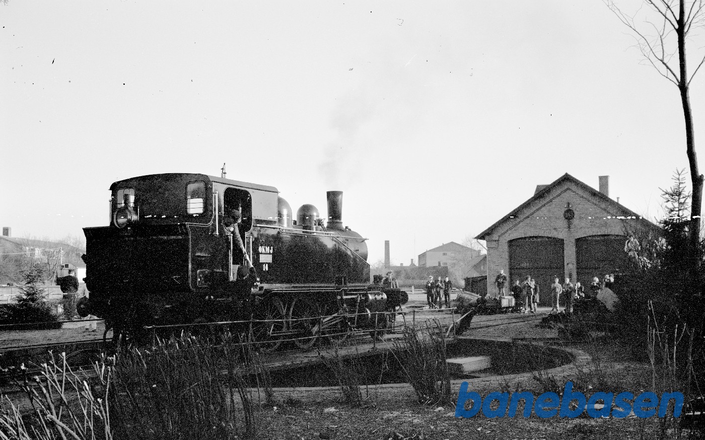 Damplokomotiv OKMJ nr. 14. Billede er fra Ringe, ved den 2 sporede remise. Blokken som ses i baggrunden er på Damhusvej Damplokomotiv OKMJ nr. 14. Billede er fra Ringe, ved den 2 sporede remise. Blokken som ses i baggrunden er på Damhusvej