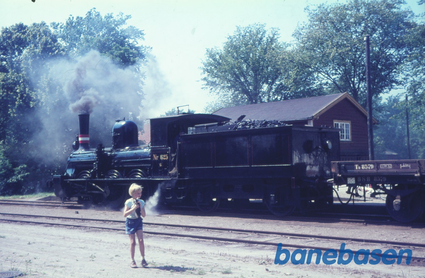 Damplokomotiv med godstog i Kirke Eskilstrup. Lille pige i forgrunden Damplokomotiv med godstog i Kirke Eskilstrup. Lille pige i forgrunden