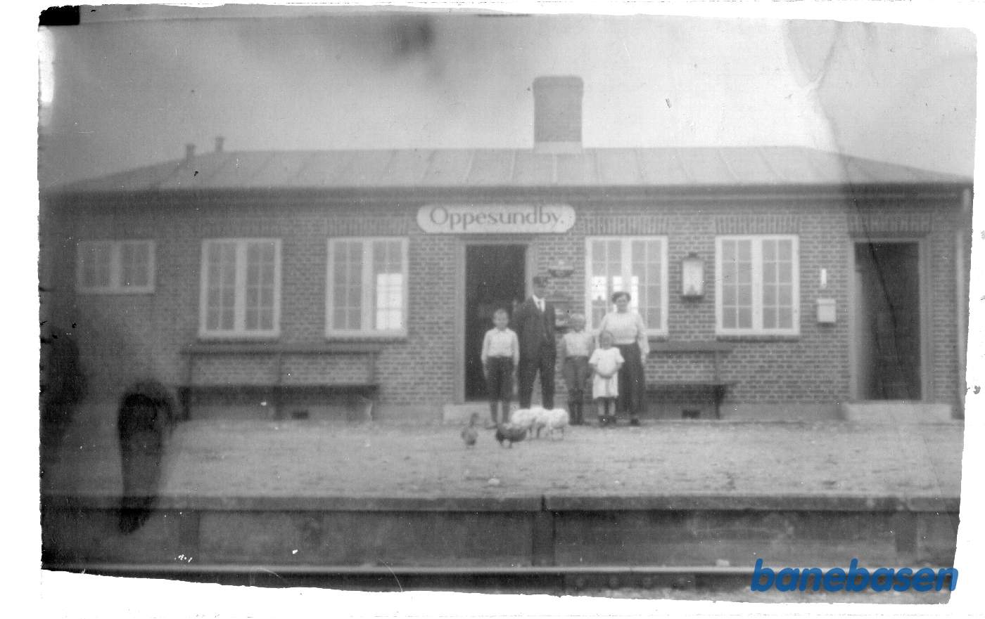 Stationsbestyrer med familie og husdyr på perronen