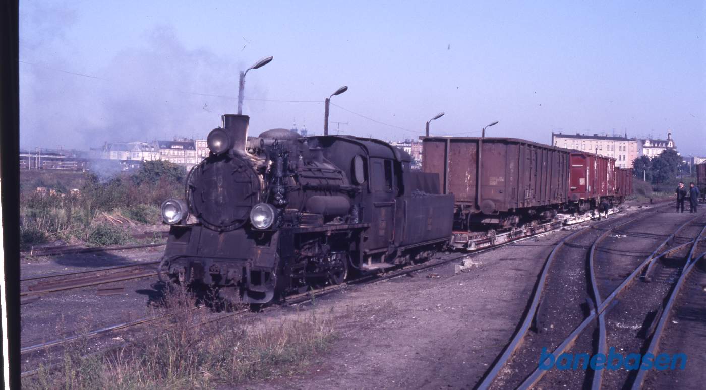 Smalsporsdamplokomotiv (750 mm) rangerer med overførte normalsporsgodsvogne