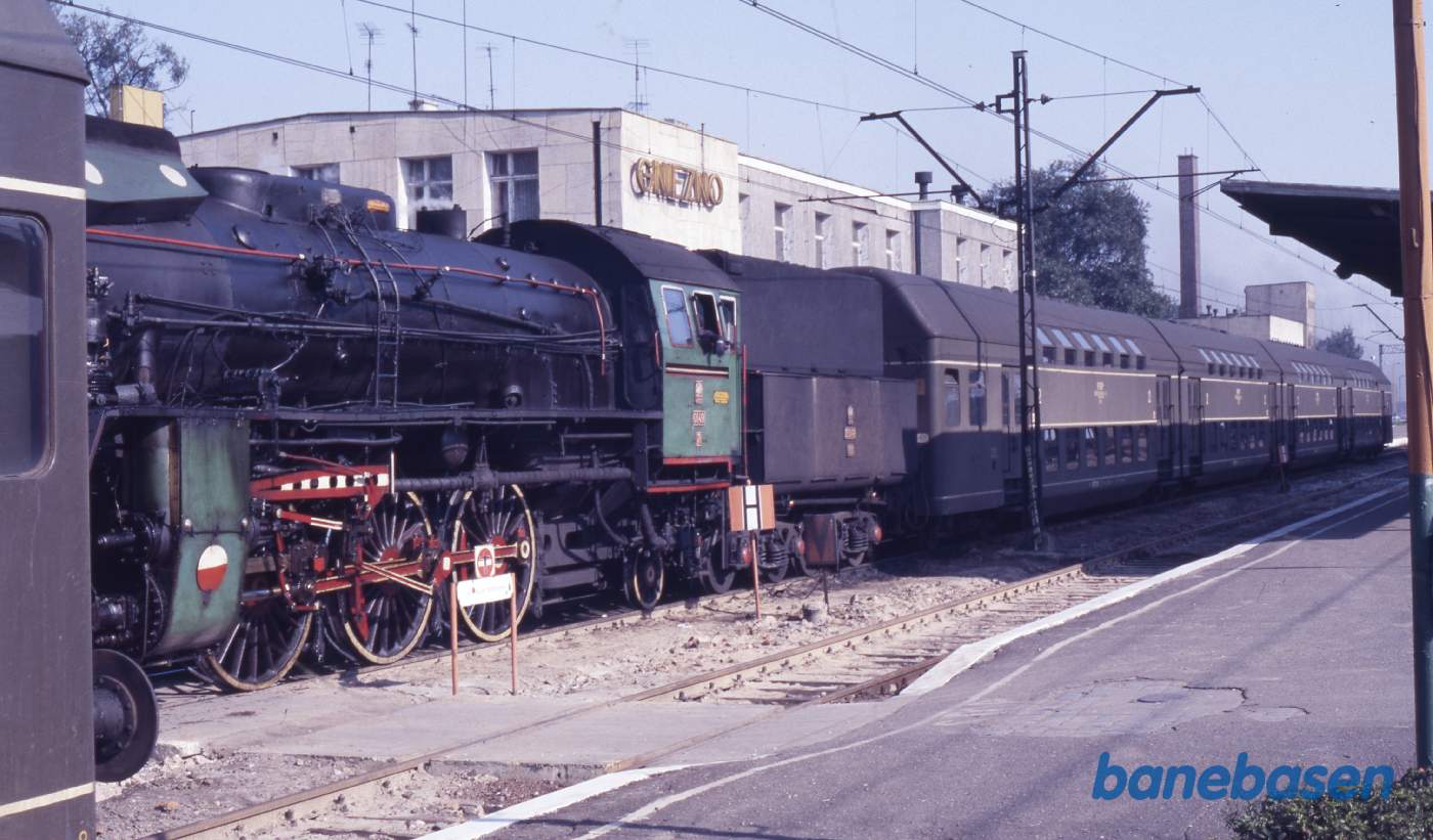 Persontog med dobbeltdækkervogne ved perron, damplokomotivet set fra siden