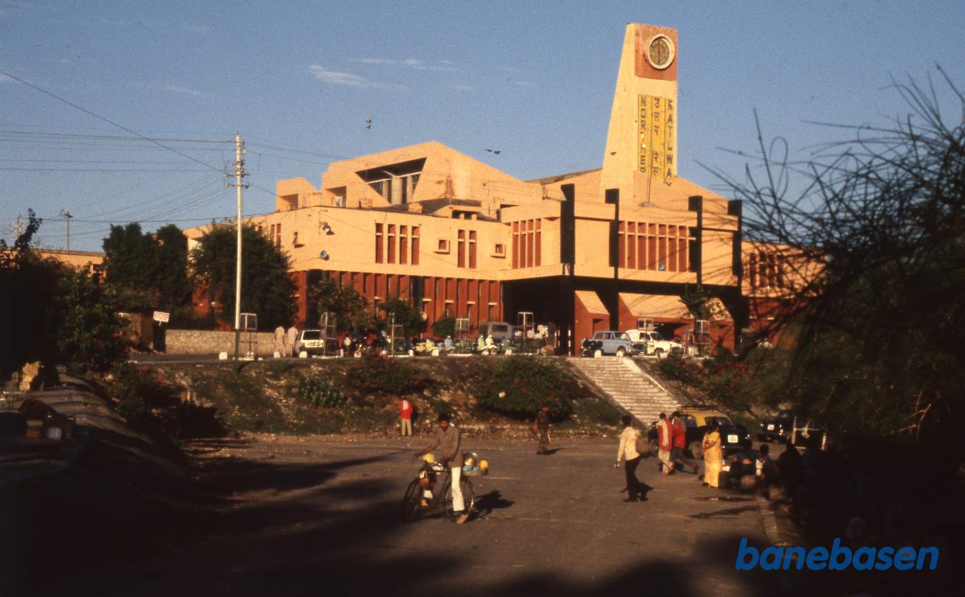Stationsbygning set fra gaden i eftermiddagssolen