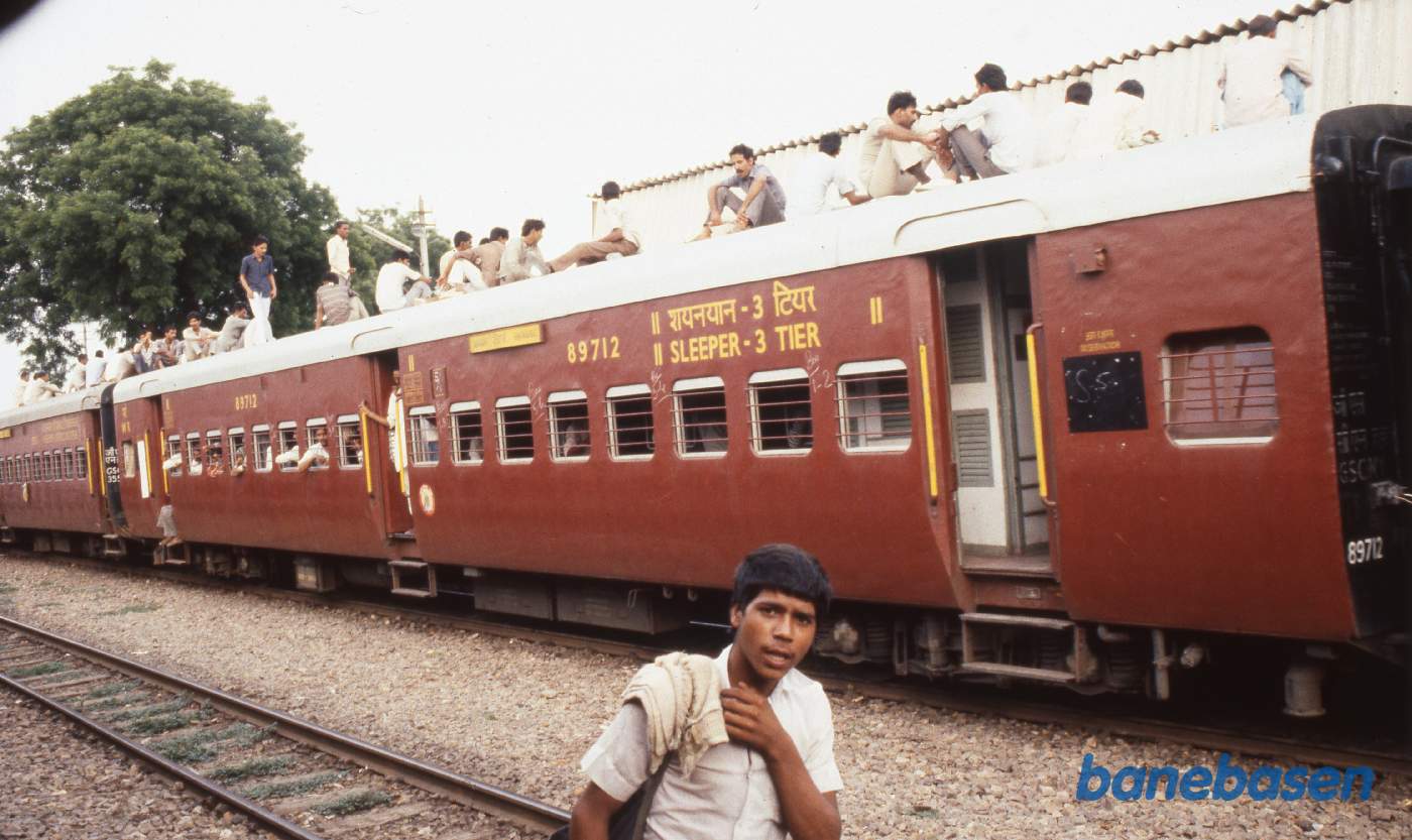 Et persontog med rejsende på taget et sted i Indien