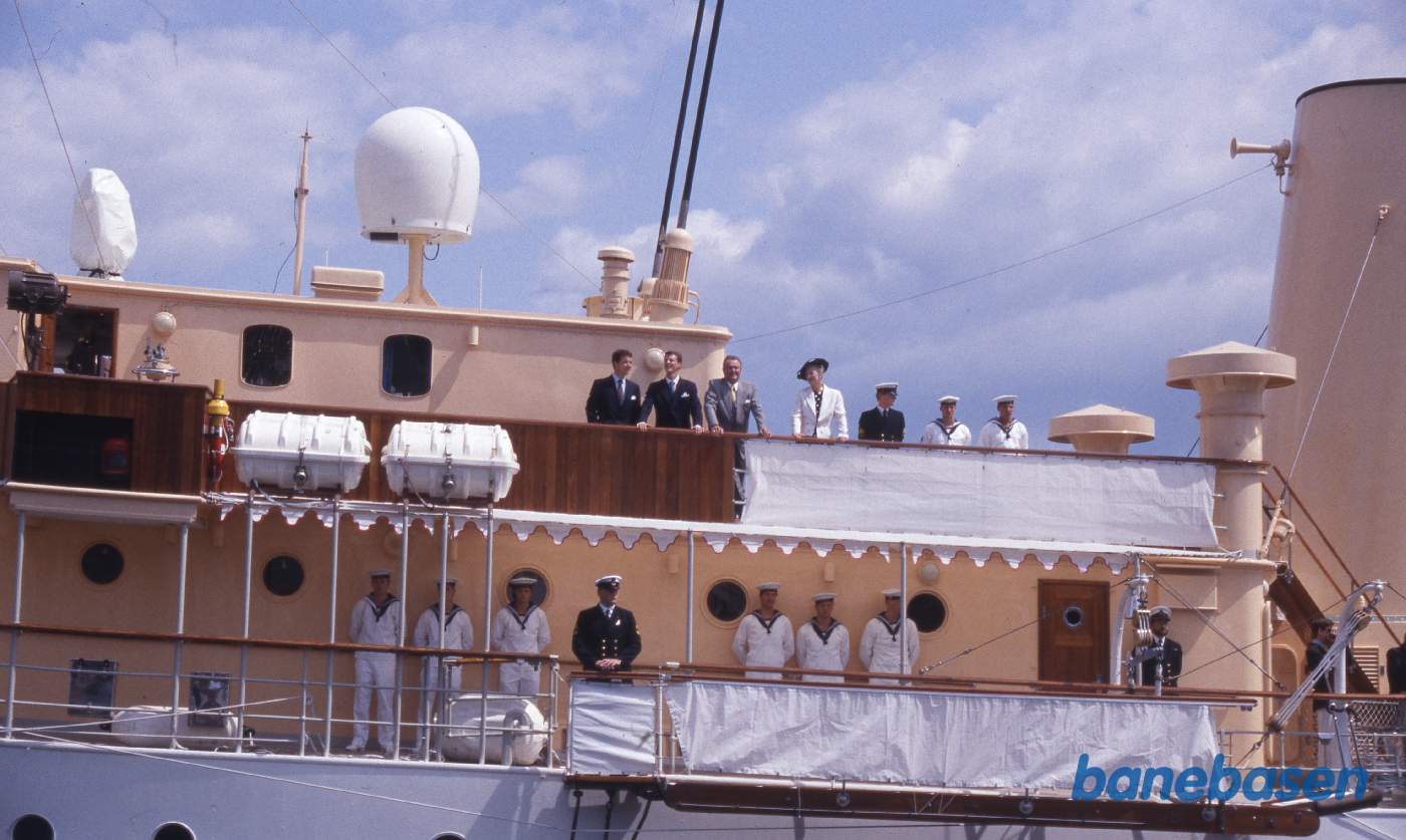 Kongefamilien på øverste dæk mens Dannebrog lægger fra kaj