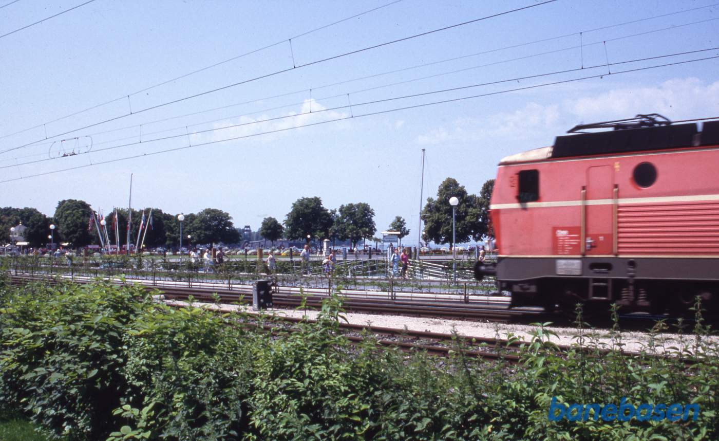 Tog på vej ud af stationen, Bodensee i baggrunden