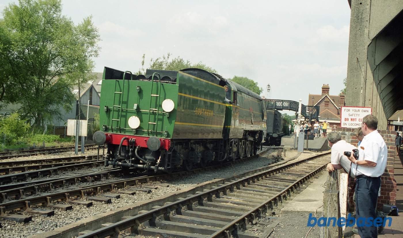 Det store grønne damplokomotiv kører op imod vognene