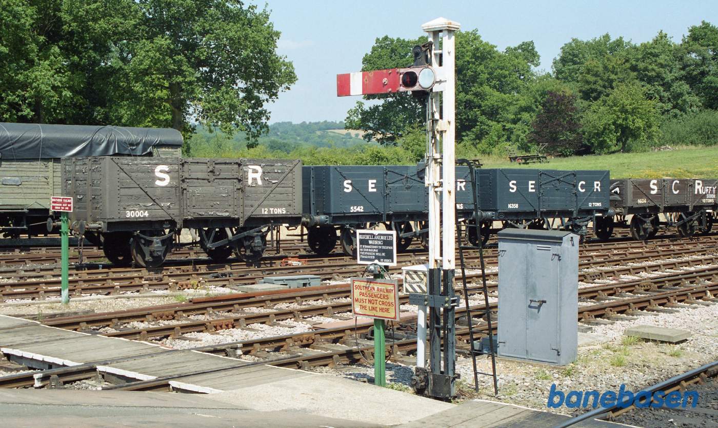 Et perronudkørselssignal og i baggrunden en række af de små korte engelske godsvogne