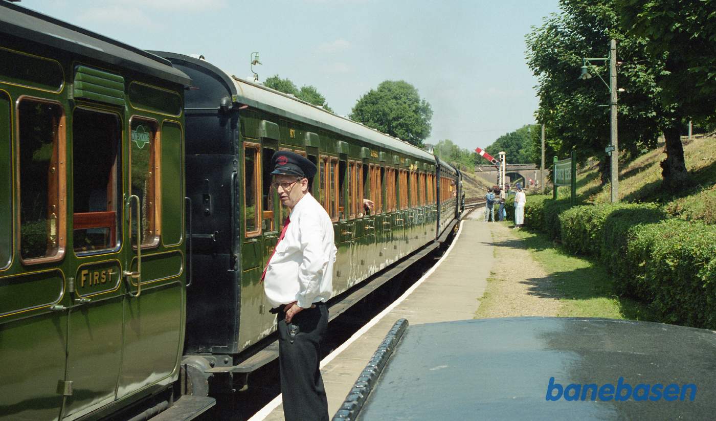 Damptoget holder klar til afgang, signalet til højre viser kør og konduktøren venter på en klarmelding