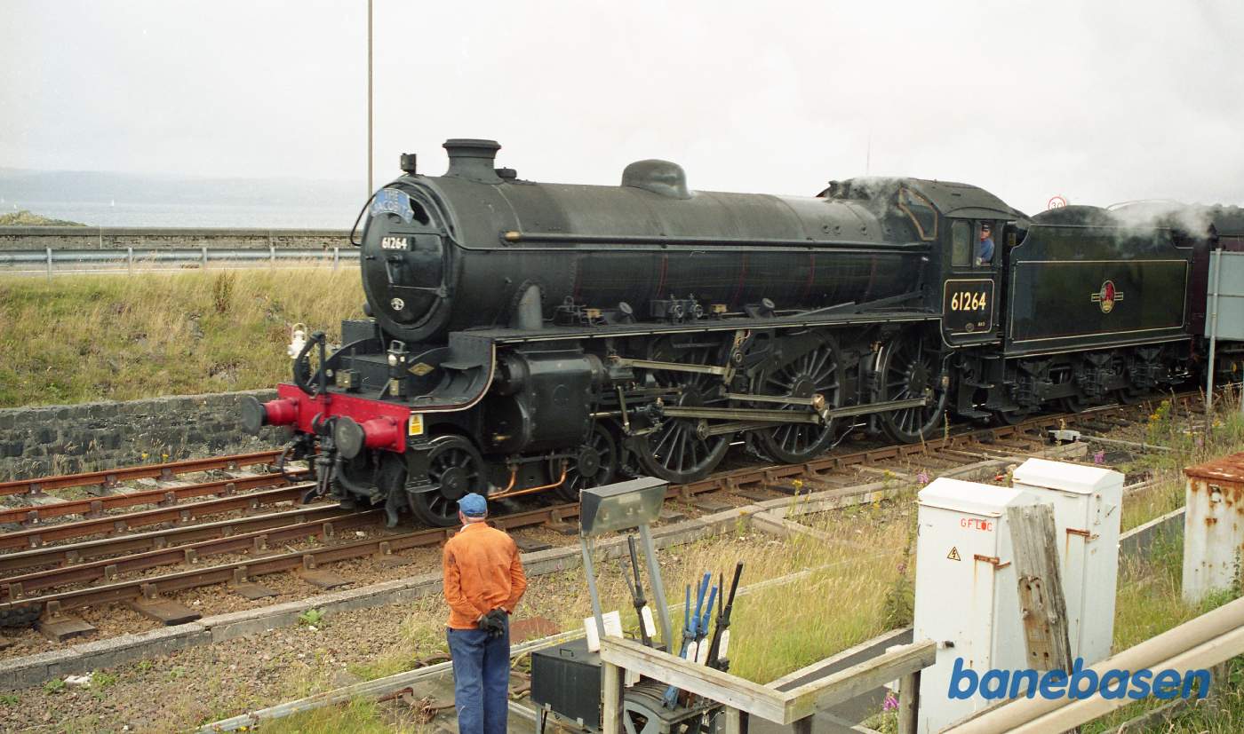 Det berømte damptog der kører mellem Fort William og Mallaig på vej ud af stationen, se havet i baggrunden