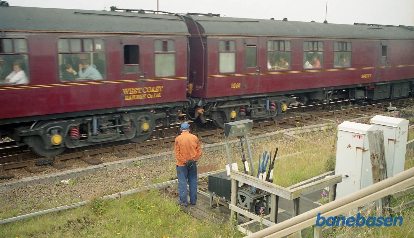 Det berømte damptog der kører mellem Fort William og Mallaig på vej ud af stationen, se signal manden i forgrunden