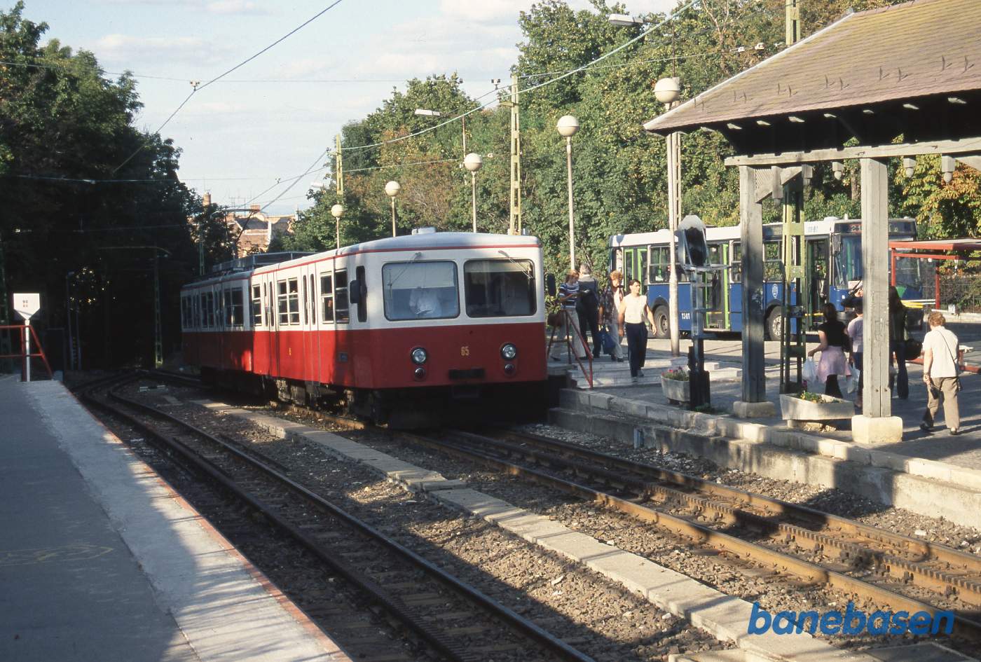 Tandhjulsbanetoget nede fra byen er på vej ind på stationen oppe på bakketoppen, hvorfra der kun er 250 meter til Børnejernbanen