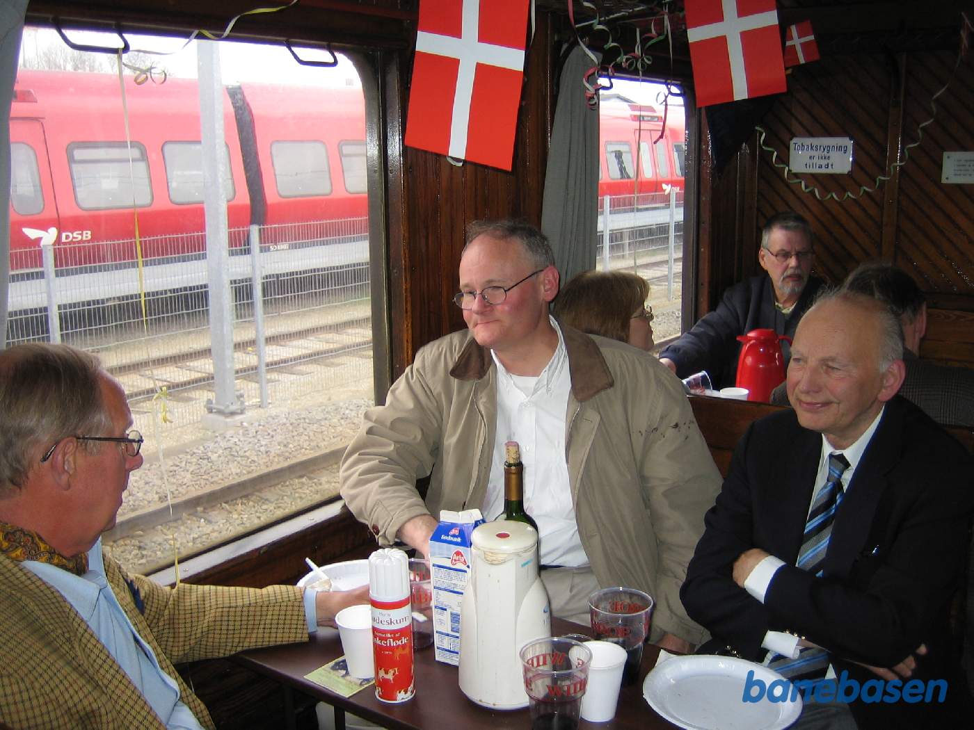 Togets vogne er fyldt med glade gæster der venter på at der skal serveres frokost i toget på vej til Helsingør Togets vogne er fyldt med glade gæster der venter på at der skal serveres frokost i toget på vej til Helsingør