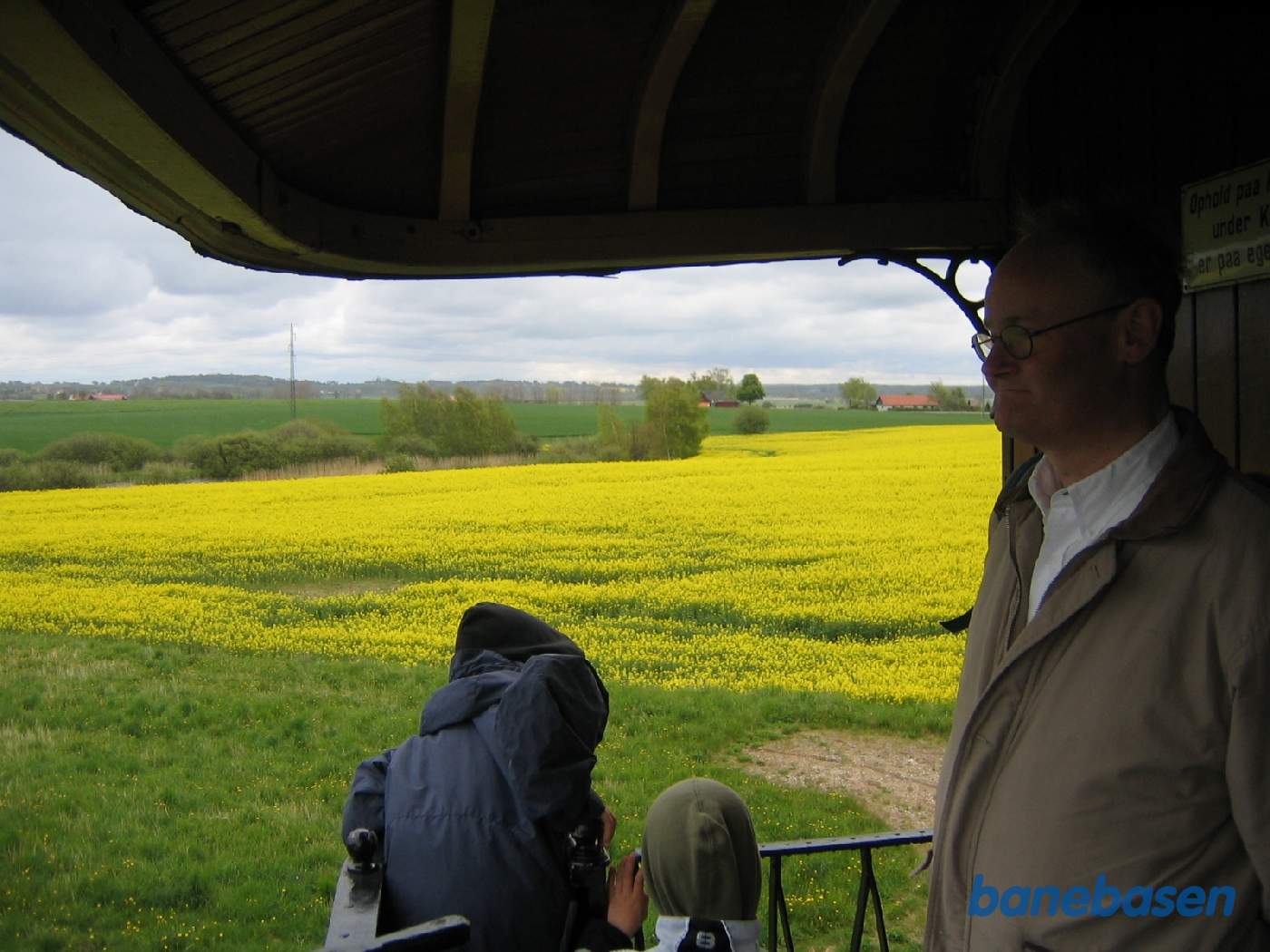 Rejsende på bagerste endeperron nyder turen gennem landskabet