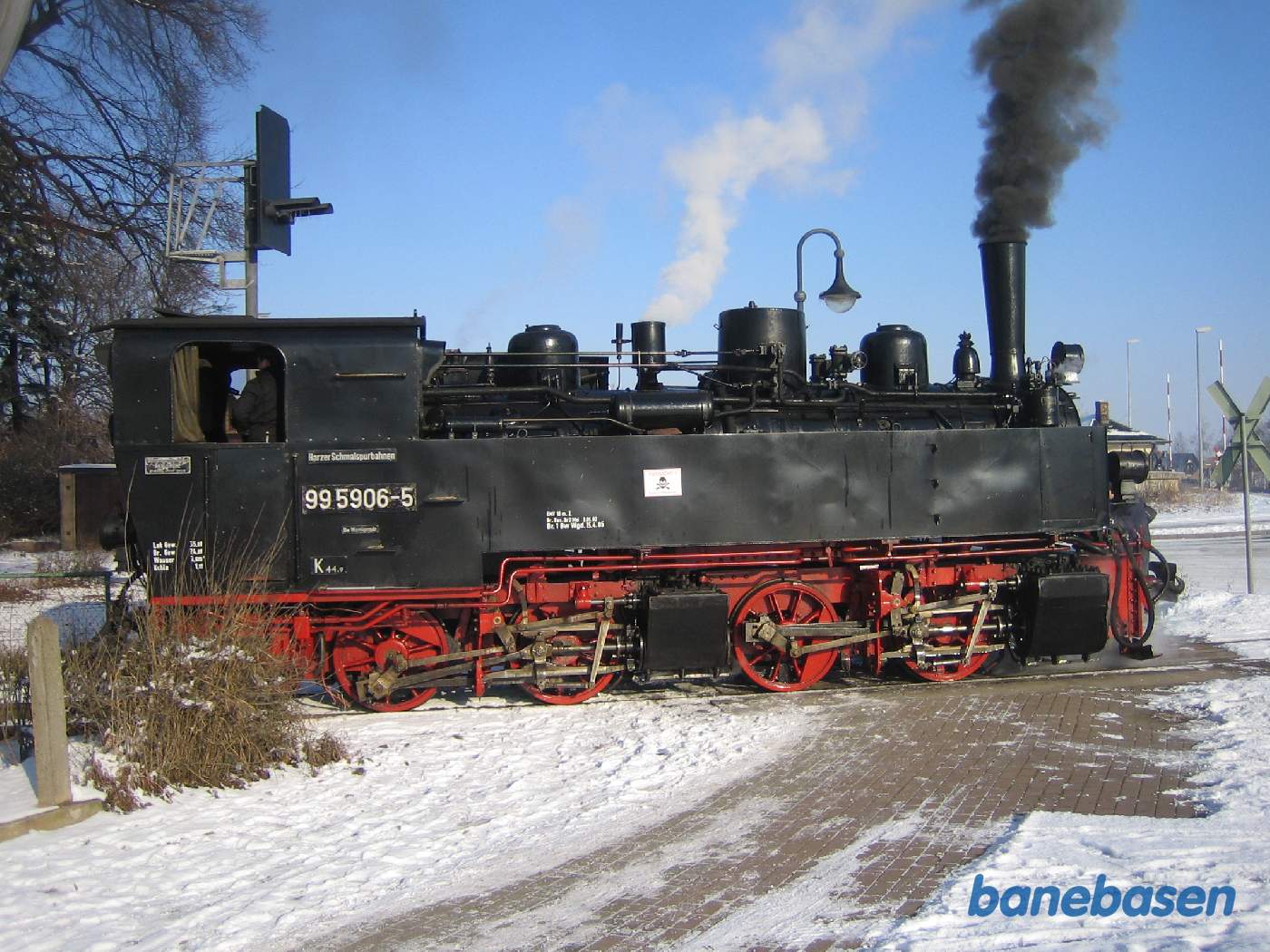 Damplokomotivet er ved at løbe om vognene. Damplokomotivet er kørt ud over vejen