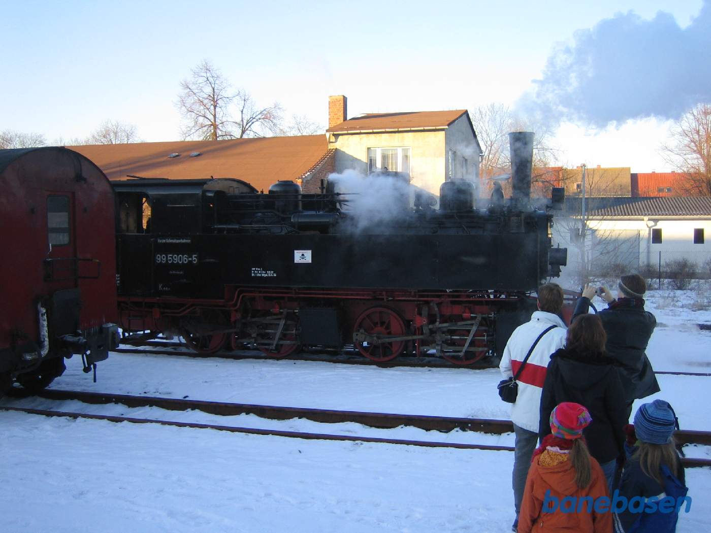 Lokomotivet omløber vognene mens folk ser på