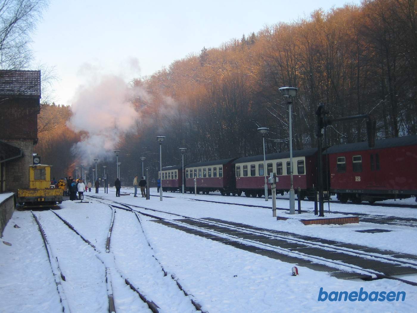 Persontoget holder på stationen mens damplokomotivet er koblet af og gemmer sig ude i venstre side af billedet