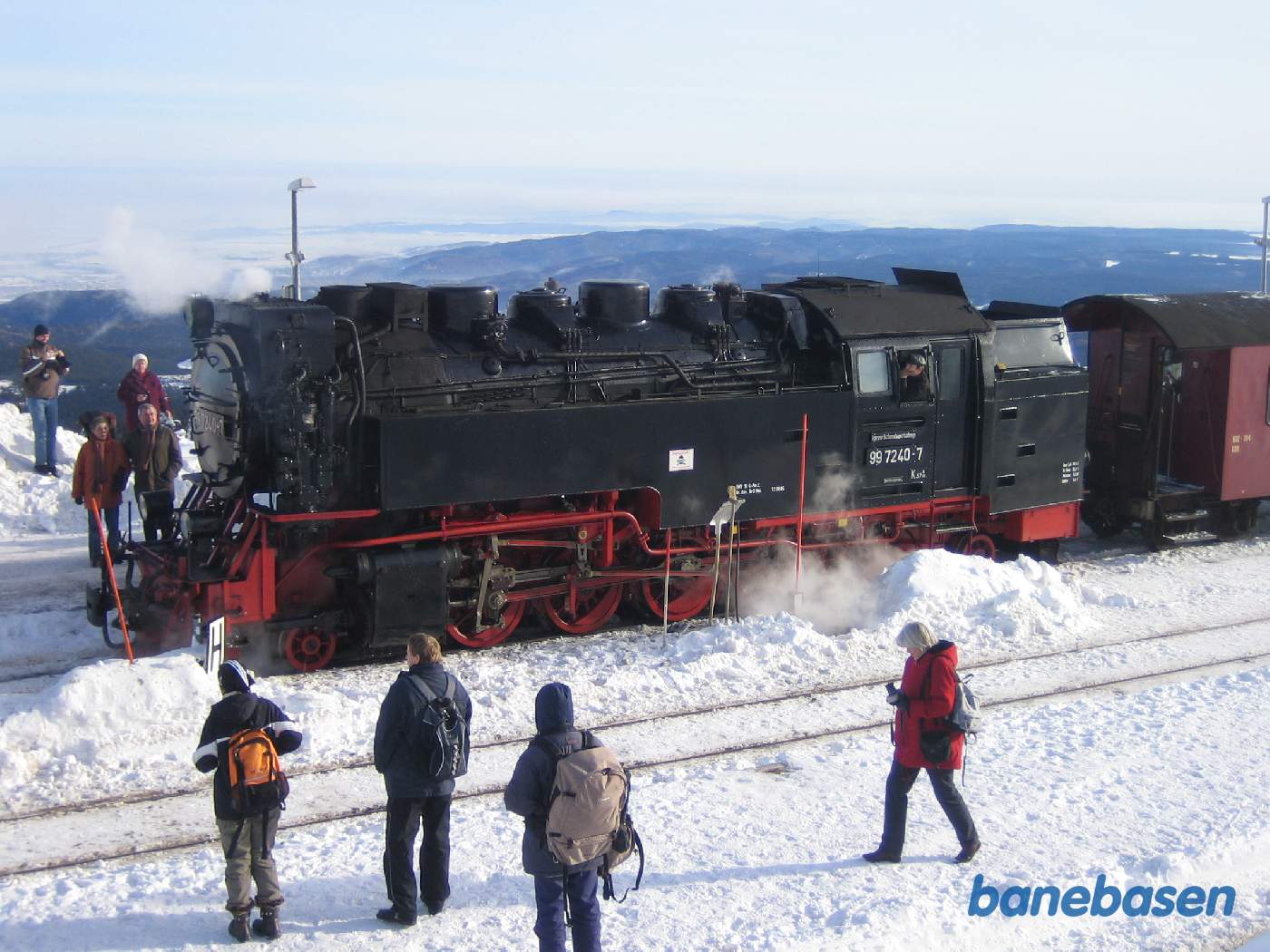 Billede af lokomotivet i sne, turisterne ser på