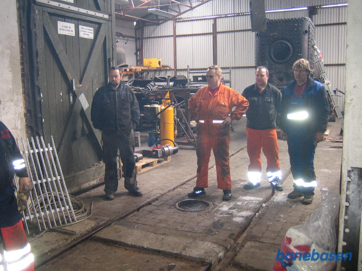 Arbejdsholdet ser veltilfredse ud efter ilægning af den nye Mercedes motor. Kedlen til HHGB Nr. 4 ses i baggrunden